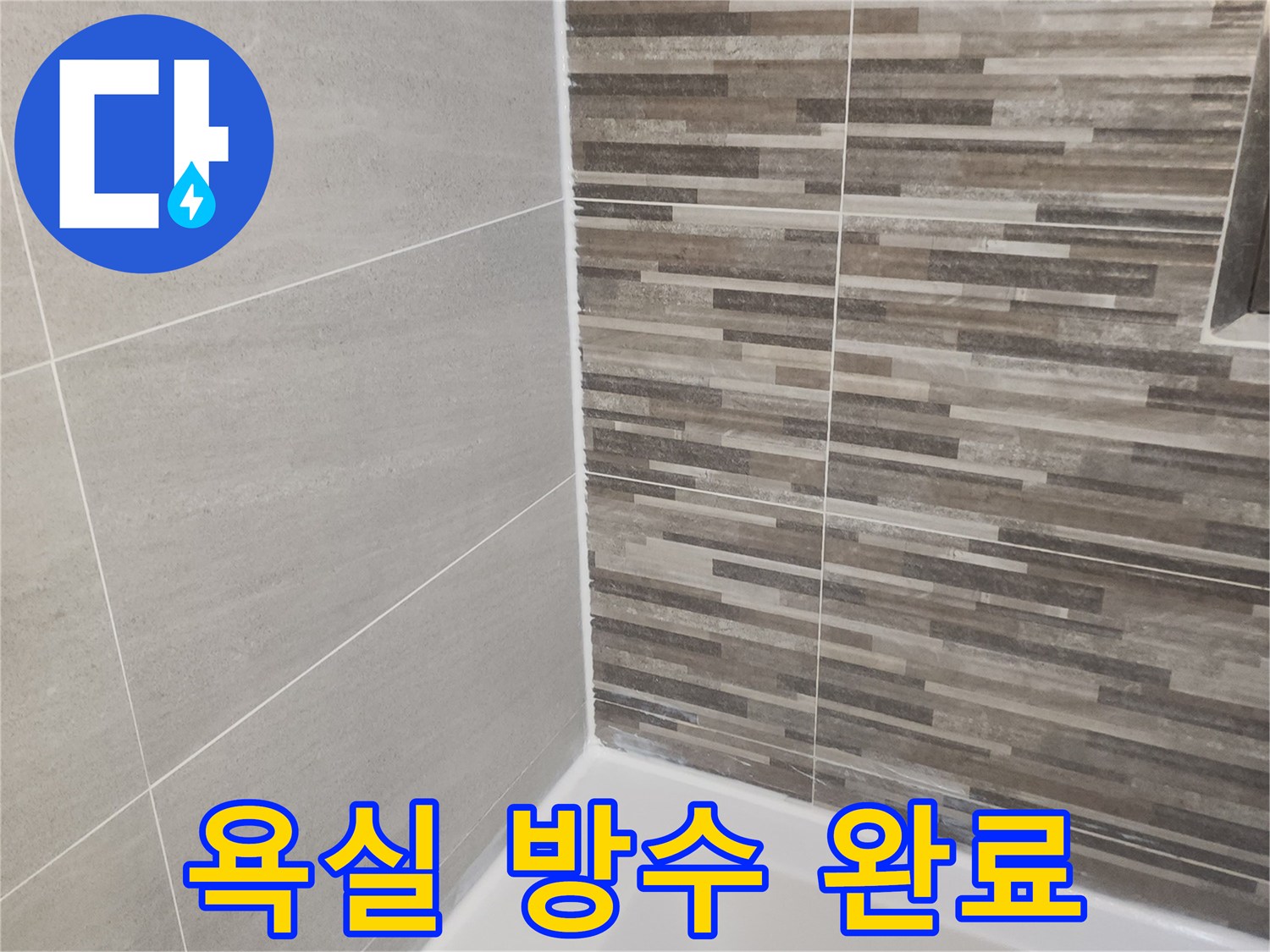누수 공사 완료 후-새롭게 시공된 욕실 바닥과 벽면 타일-그리고 깨끗한 실리콘 마감 상태를 보여줍니다.