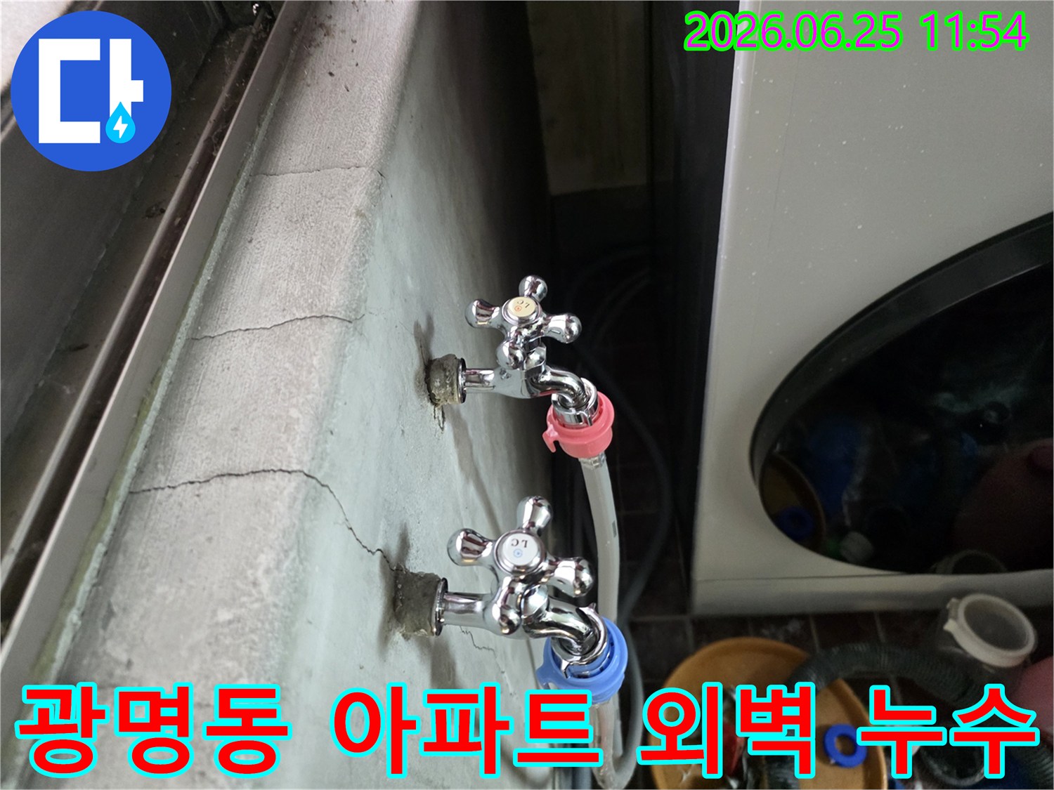 광명동 아파트 외벽에 설치된 수도꼭지에서-물이 새어 벽면이 젖어 있는 상황을 보여주는 이미지입니다.