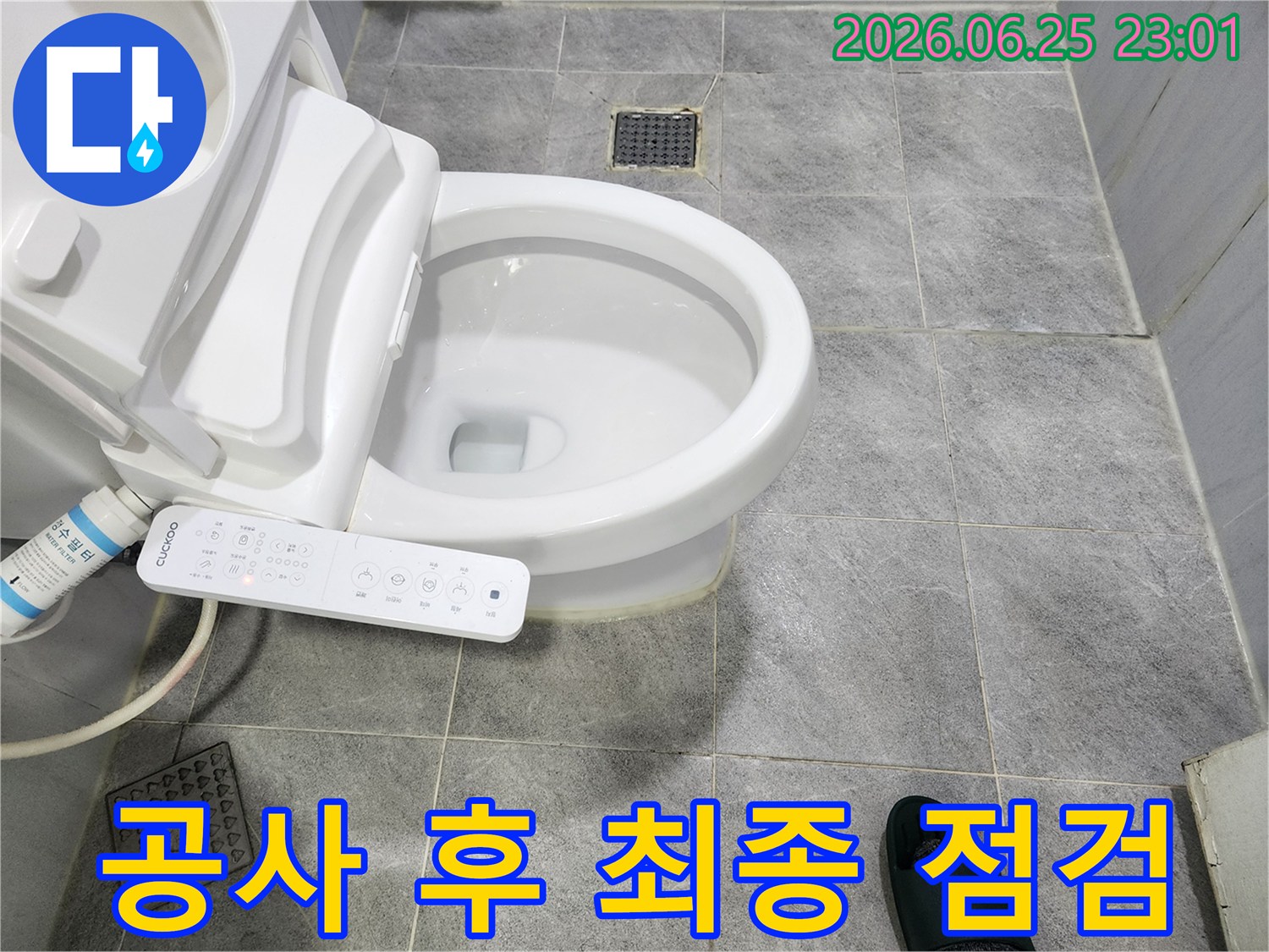 누수-공사가-완료된-화장실-바닥과-변기-주변을-최종적으로-점검하고-있는-모습