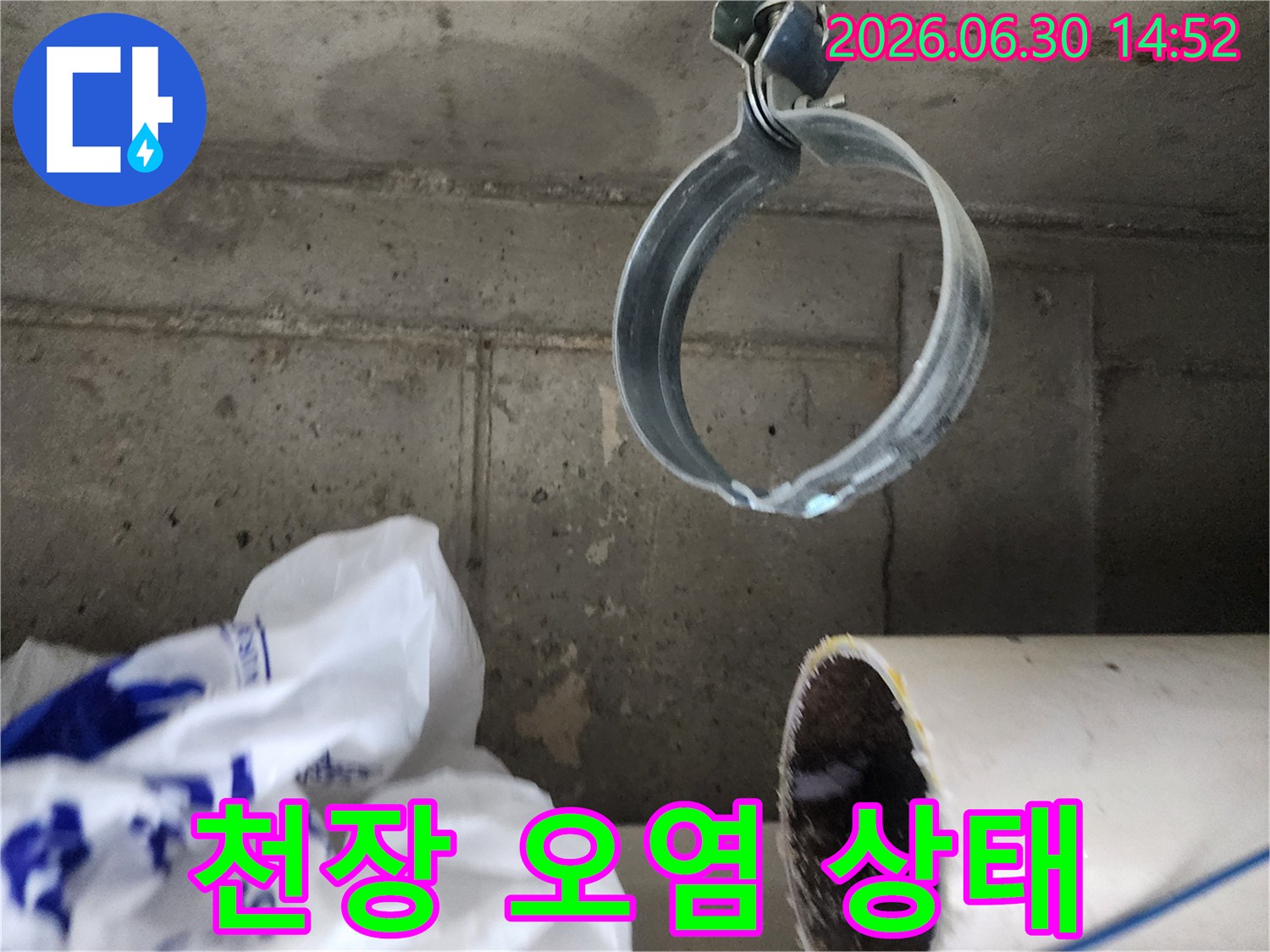 물기로 인해 오염되고-변색된 콘크리트 천장과-배관 고정 밴드의-누수 현장 사진
