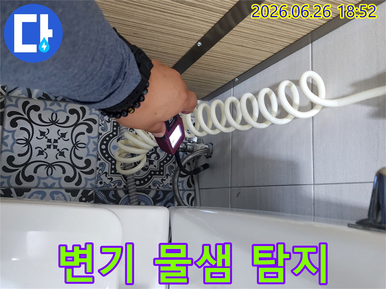 전문가가 욕실 변기 주변에서 누수 탐지 장비를 이용해 물샘을 확인하고 있습니다.