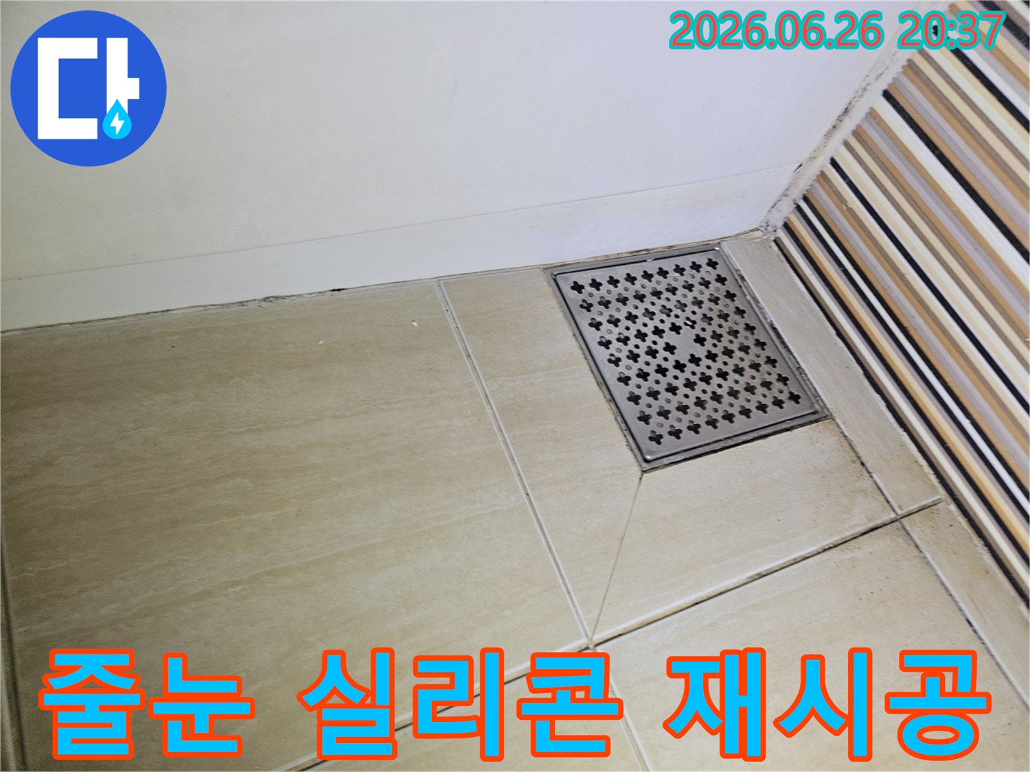 욕실 바닥 타일의-줄눈과 벽면 경계에-나타난 오염과-변색은-실리콘 노후화로 인한-누수 가능성을-시사하며-재시공이 필요함을 보여줍니다