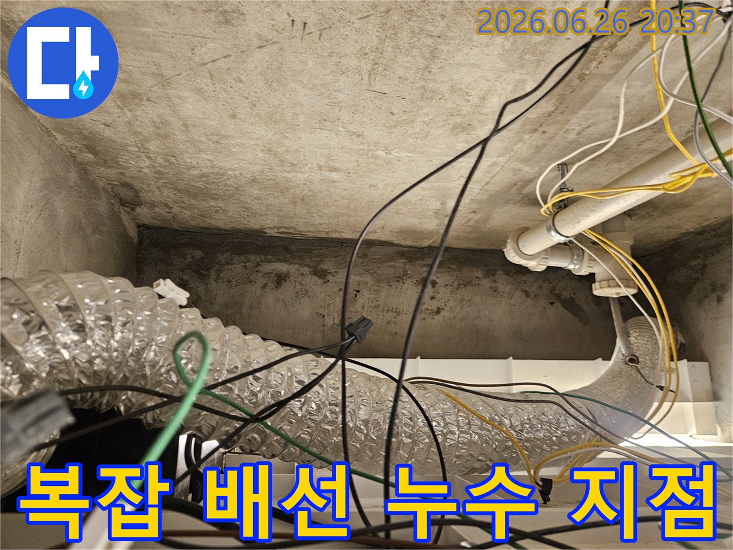 이 이미지는 천장 내부의 복잡하게 얽힌 전기 배선과-덕트-그리고 콘크리트 표면의-누수 흔적을 통해-누수 지점을 파악하는 과정을 보여줍니다.