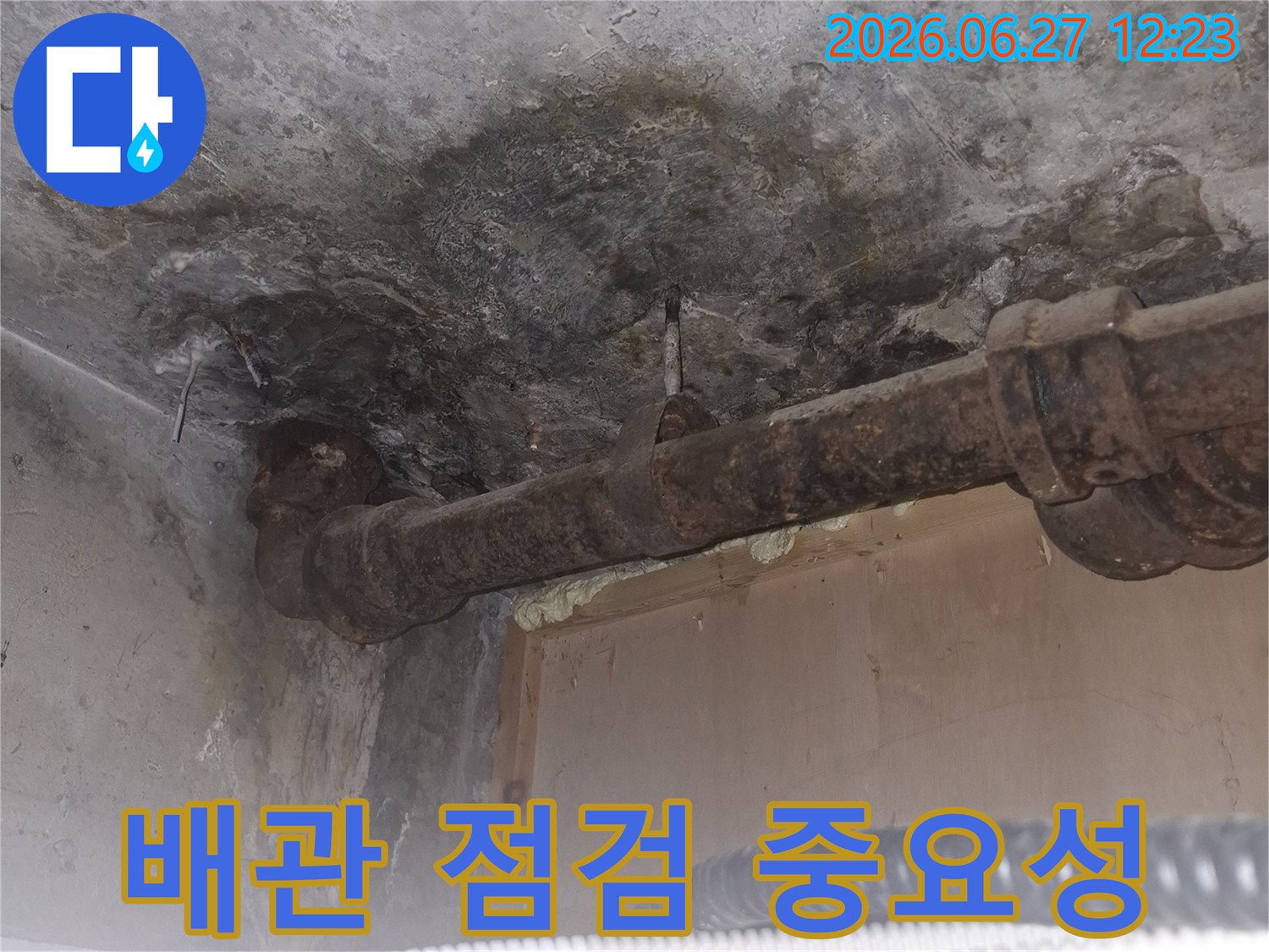 오래된 아파트의-녹슨 배관 주변에서-발견된 누수 흔적을-보여주는-젖은 콘크리트 바닥과-부식된 파이프의-상세 이미지입니다