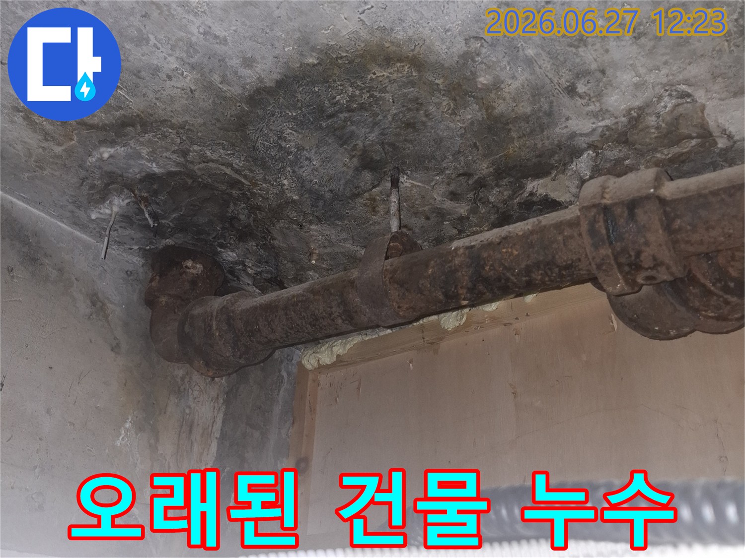 오래된 아파트의-녹슨 배관 주변에서-발견된 누수 흔적을-보여주는-젖은 콘크리트 바닥과-부식된 파이프의-상세 이미지입니다