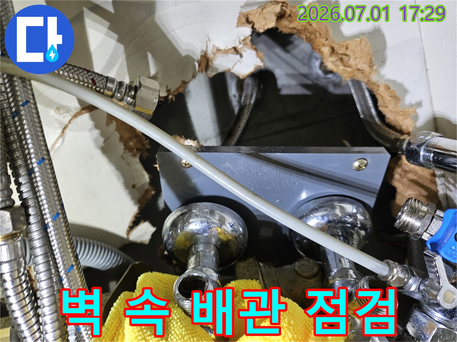 벽 안쪽에서-수도 배관의-연결 부위에서-누수 여부를-점검하는-작업 현장 사진