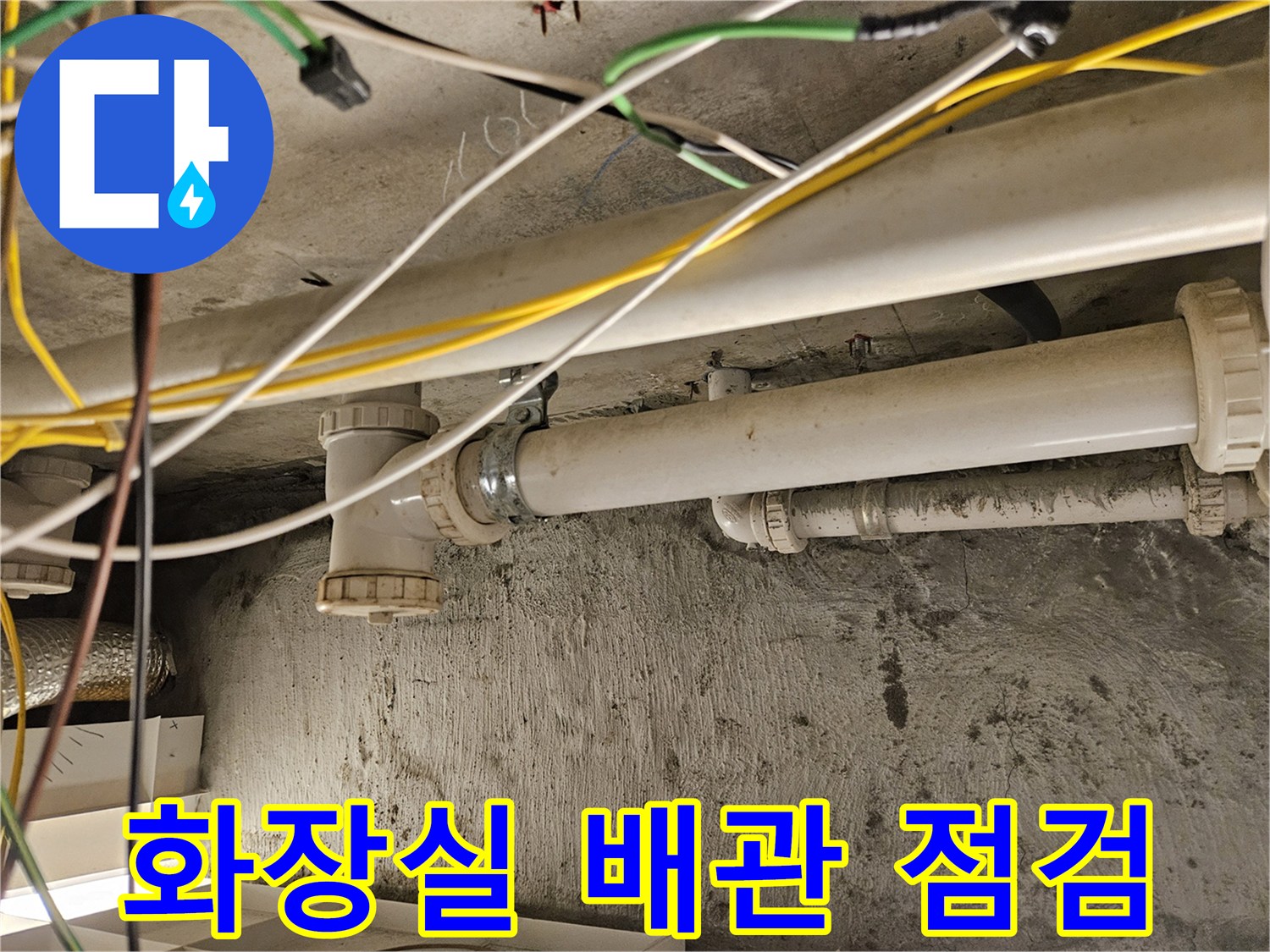 아래층 화장실 천장에 노출된 하수도 배관과 전선 상태를 확인하는 모습