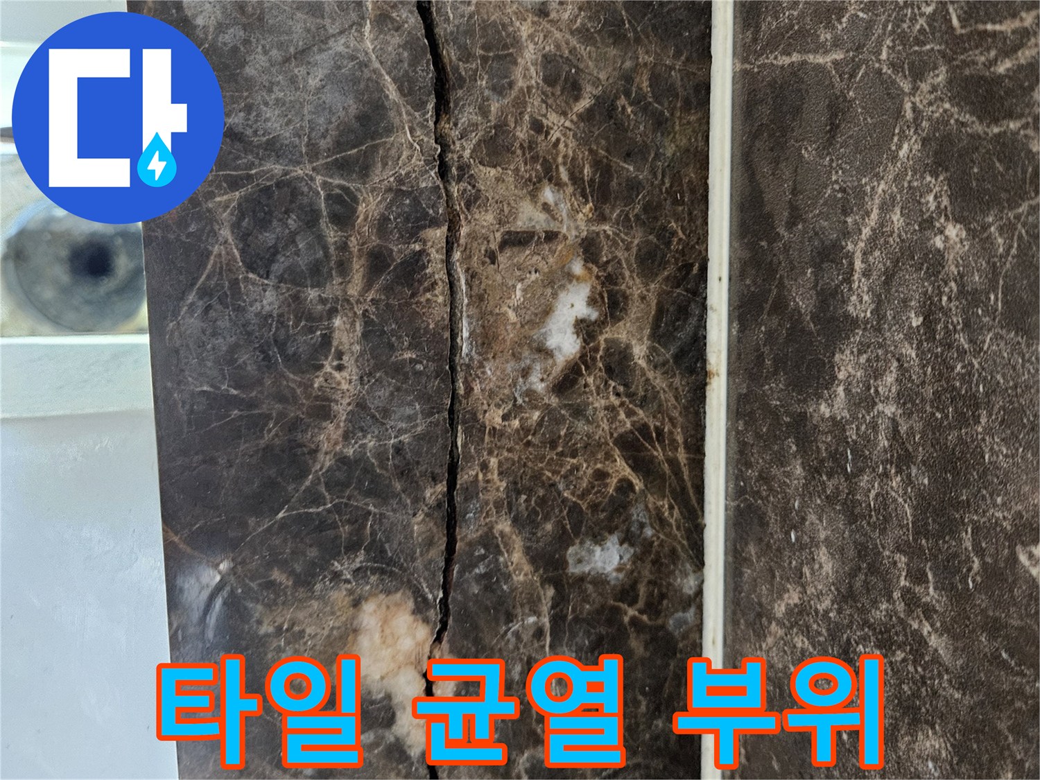어두운 색상의 대리석 패턴 타일에 길게 발생한 균열 상태