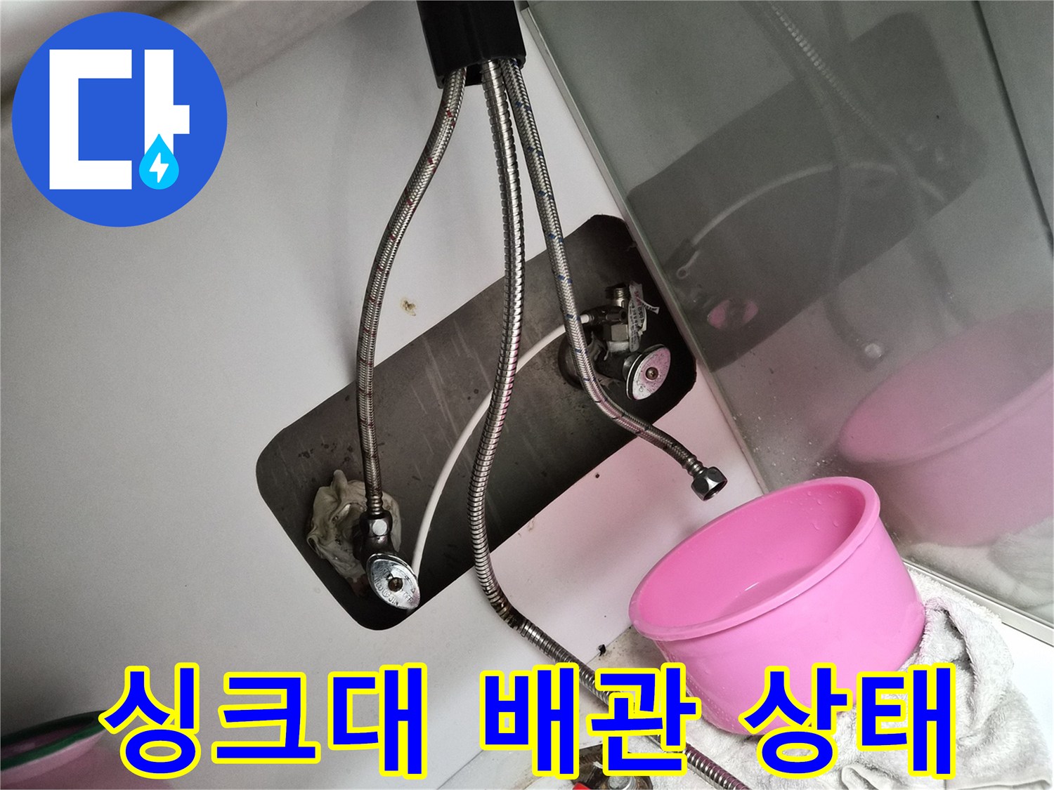 싱크대 하부장에 노출된 금속 소재의 급수 호스와 밸브 점검 장면