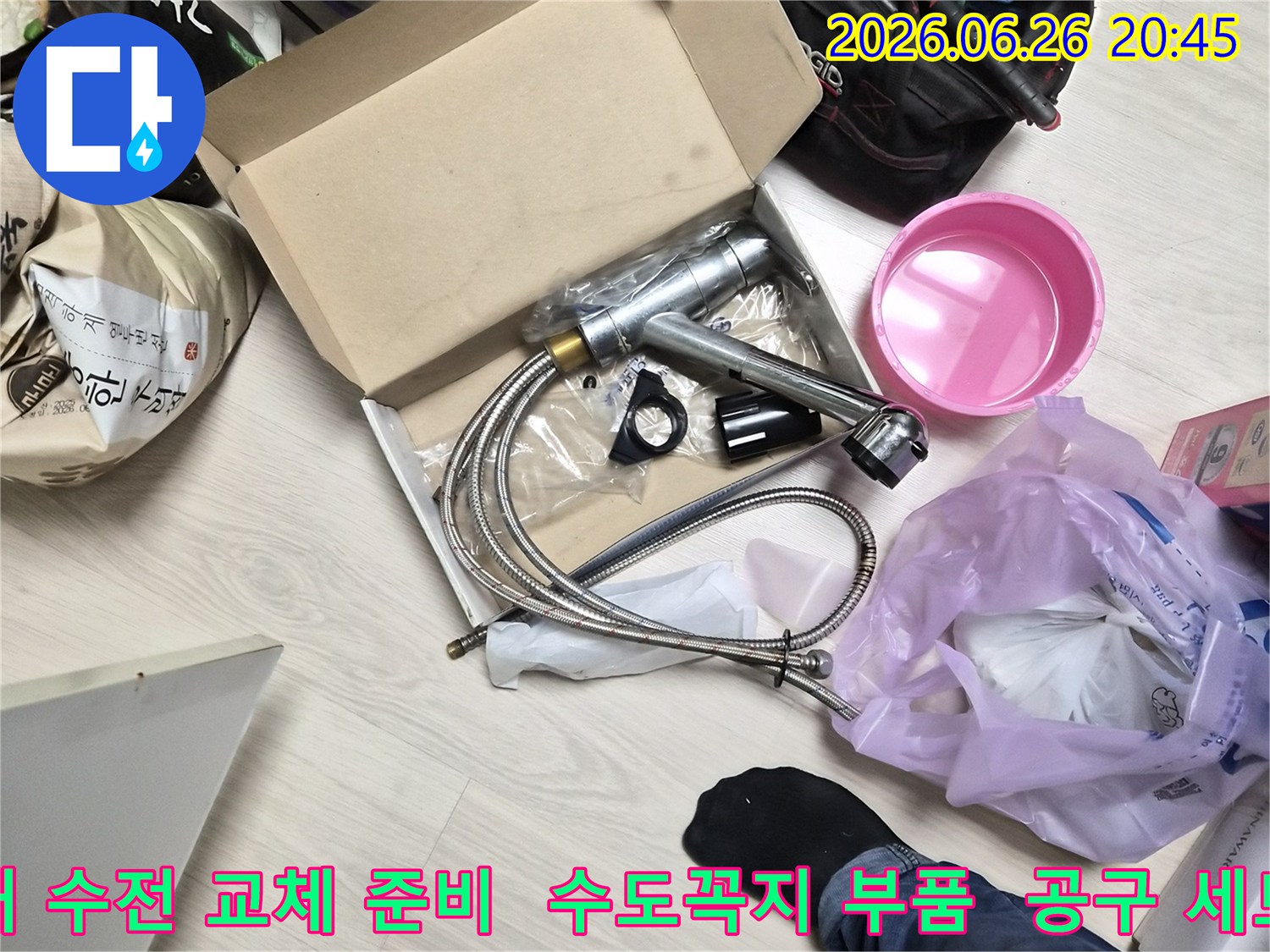 주방 수전 교체를 위한-새 제품과-다양한 작업 도구들이-바닥에 놓여 있습니다