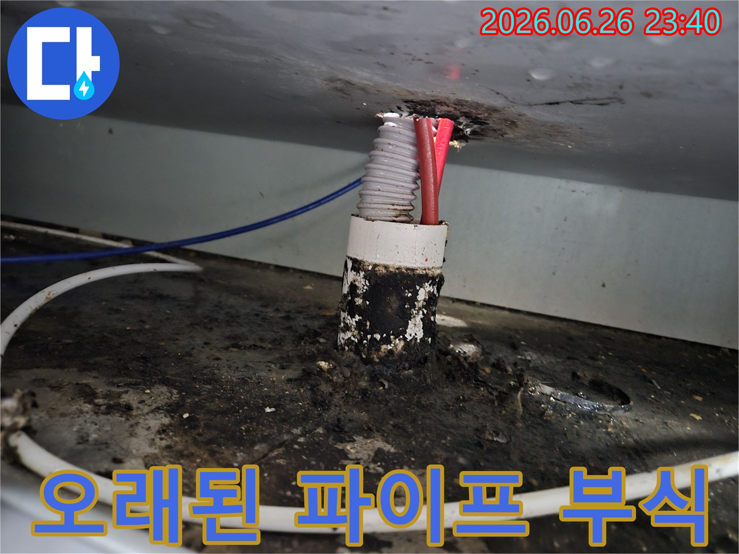 주택 내부의 오래된 파이프 틈새에서 발생한 심각한 부식과-그로 인한 누수 흔적을 보여줍니다.