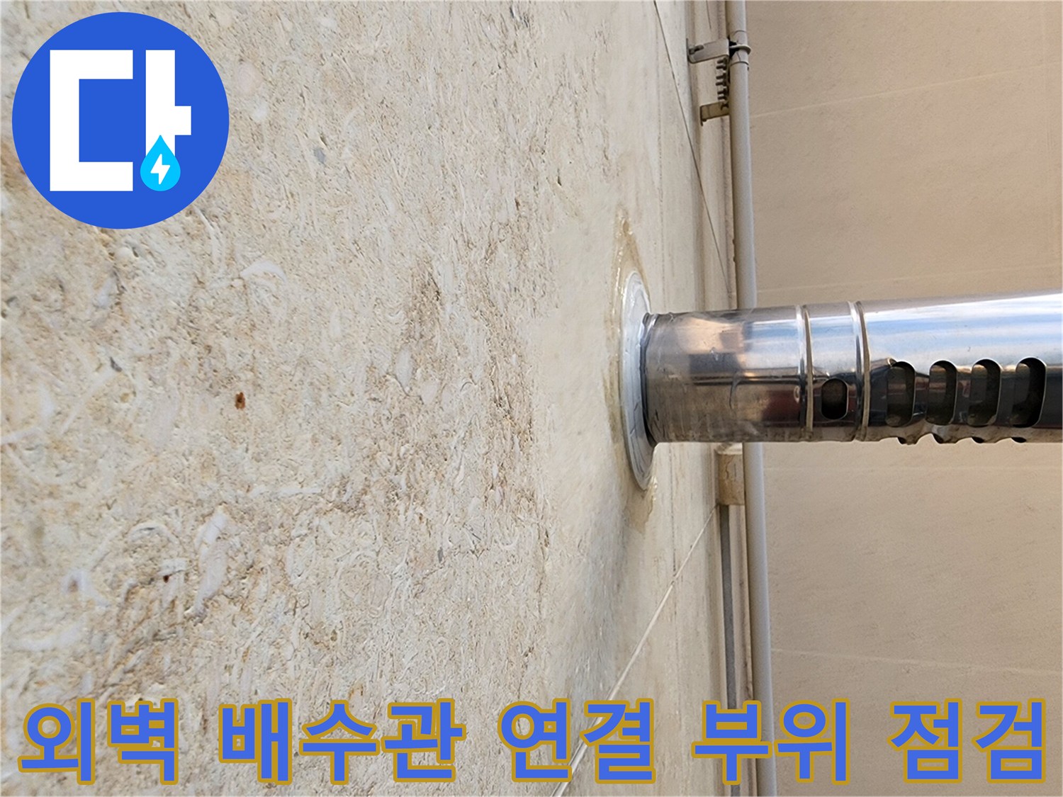 석재 외벽과 스테인리스 배수관이 만나는 지점의 상세 사진