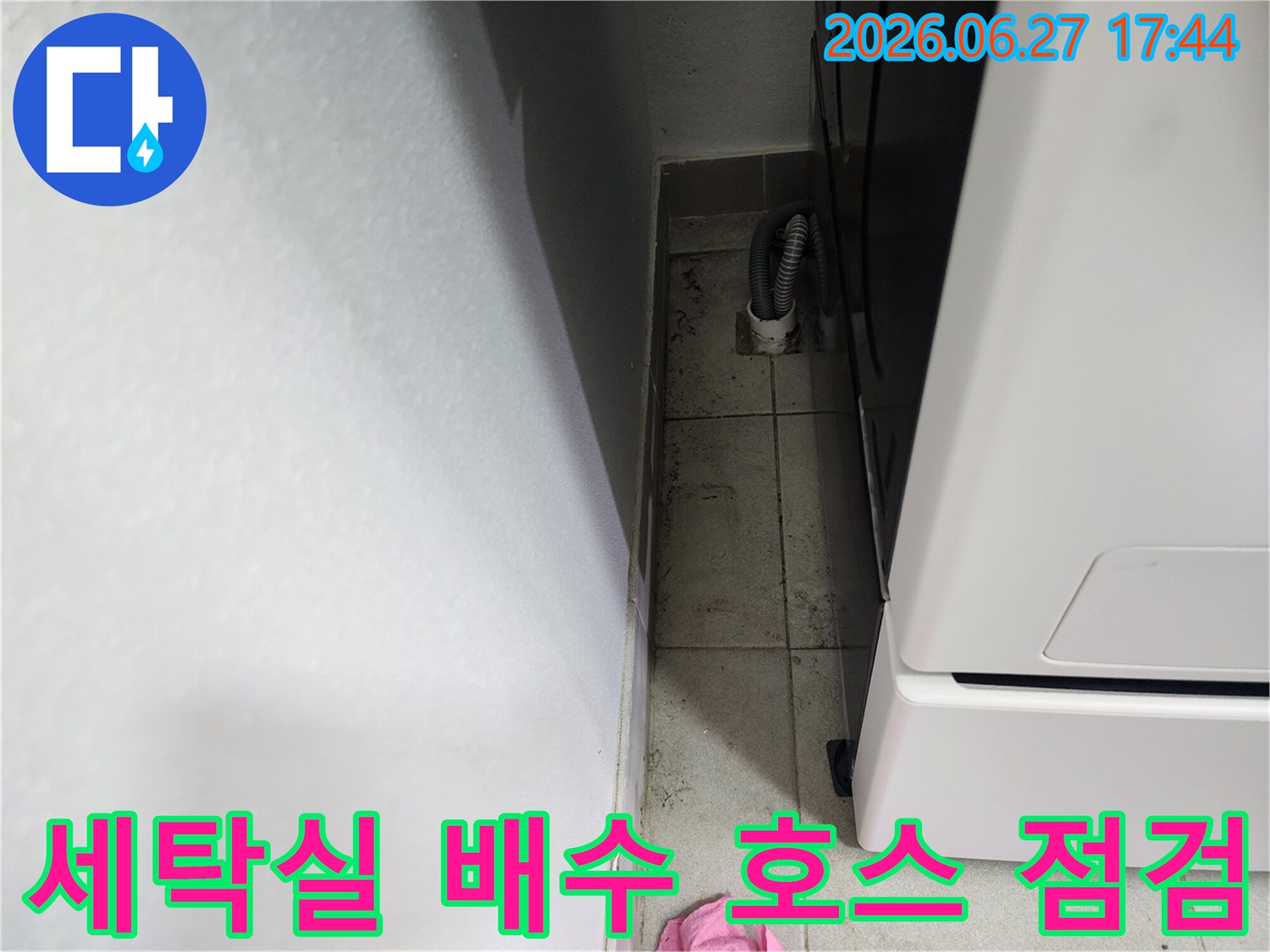 세탁실-배수-호스가-연결된-바닥-배수구-주변의-오염-상태를-보여주는-누수-현장-사진입니다