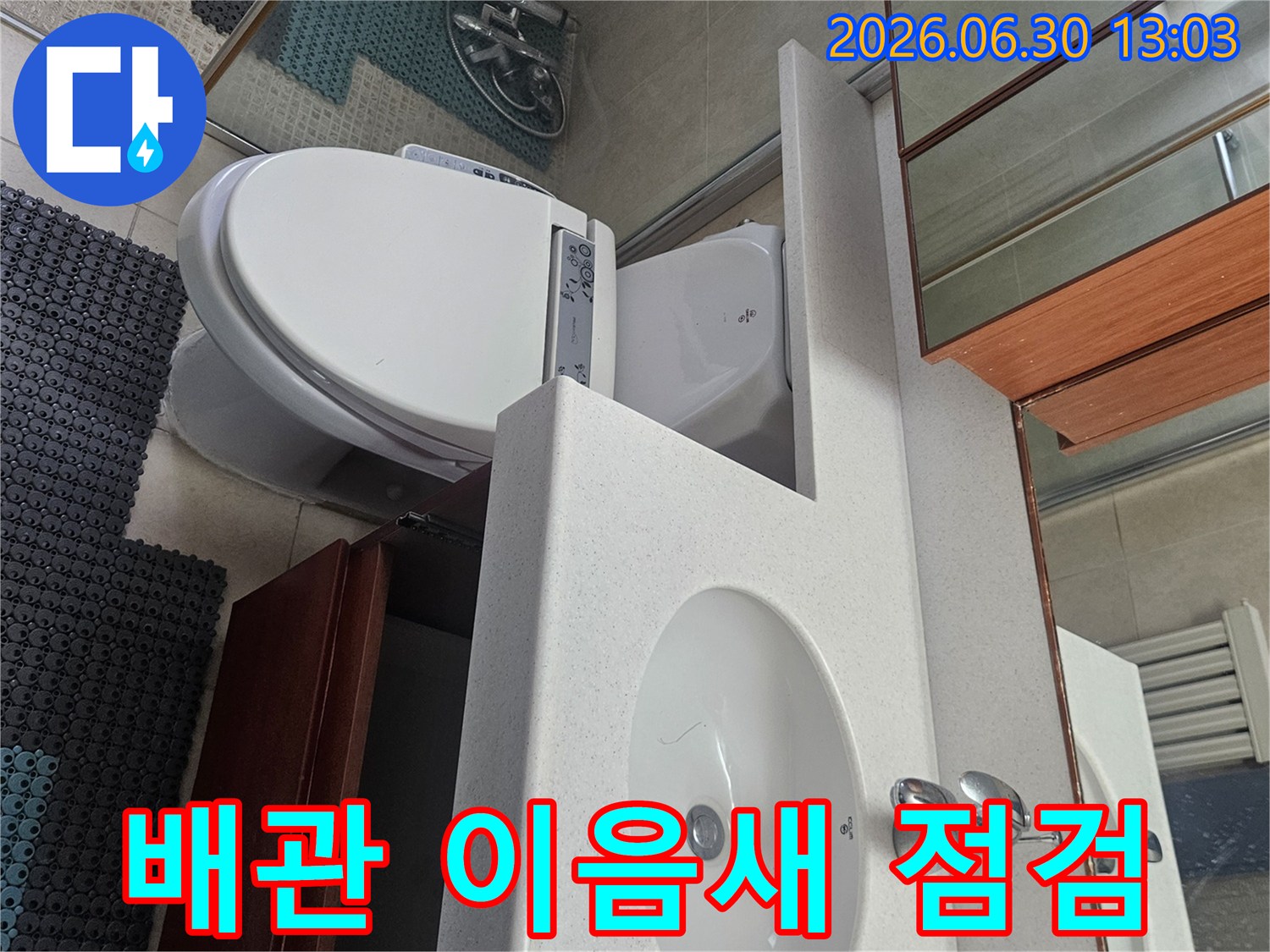 누수 엔지니어가 안양 호계동 아파트 욕실의 세면대와 변기 주변 배관 이음새를 꼼꼼히 점검하는 모습