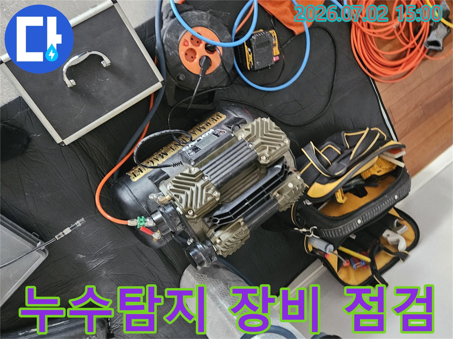 누수 탐지를 위한-다양한 전문 장비들이 바닥에 놓여있으며-작업 전 최종 점검을 진행하는 모습입니다