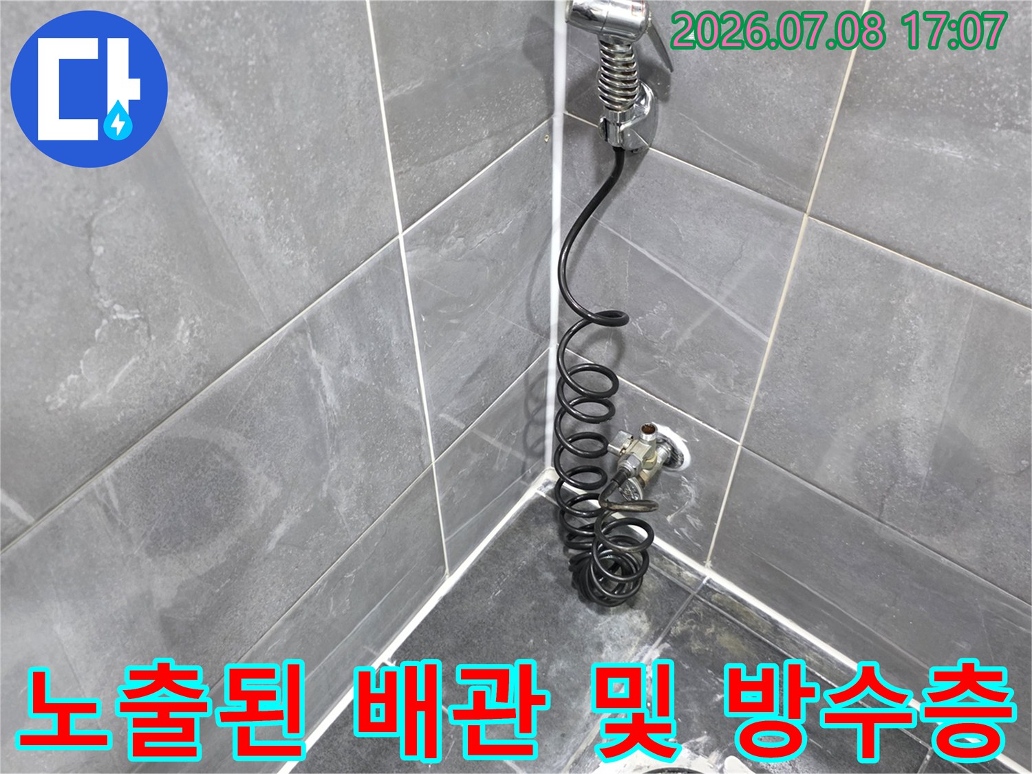 타일을 제거하고 노출된 화장실 하수 배관 주변의 구조적 상태를 점검하는 현장 사진입니다.