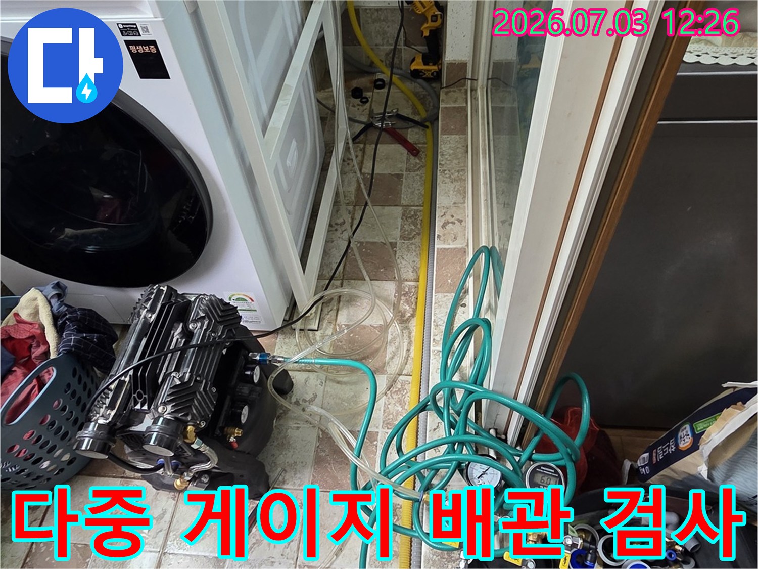여러 개의 압력 게이지와 호스가 연결된 전문 설비로 세탁실 내부를 정밀 점검하는 모습