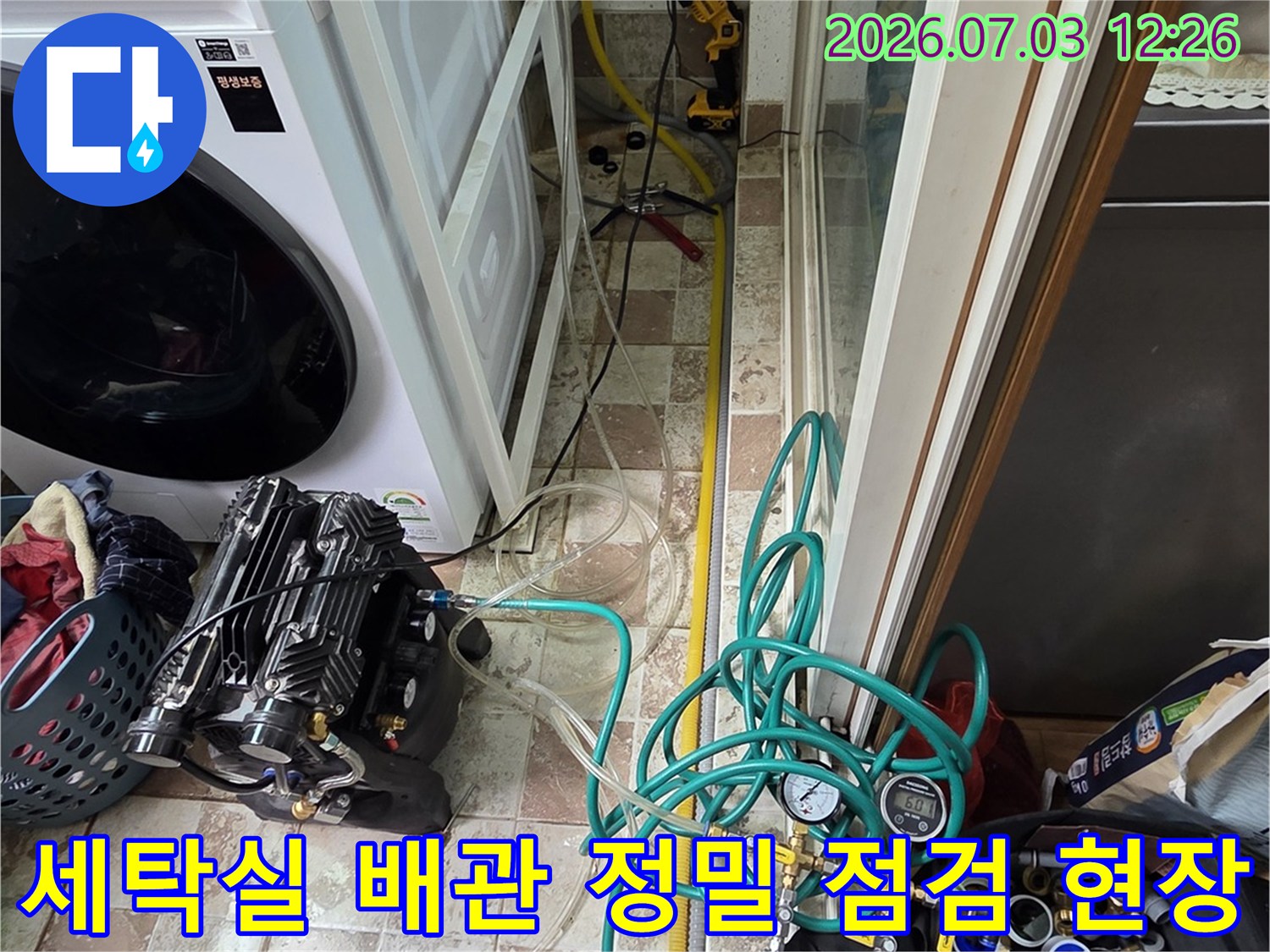 정교한 공압 테스트 장치와 연결된 호스들이 배치된 세탁기 옆의 모습