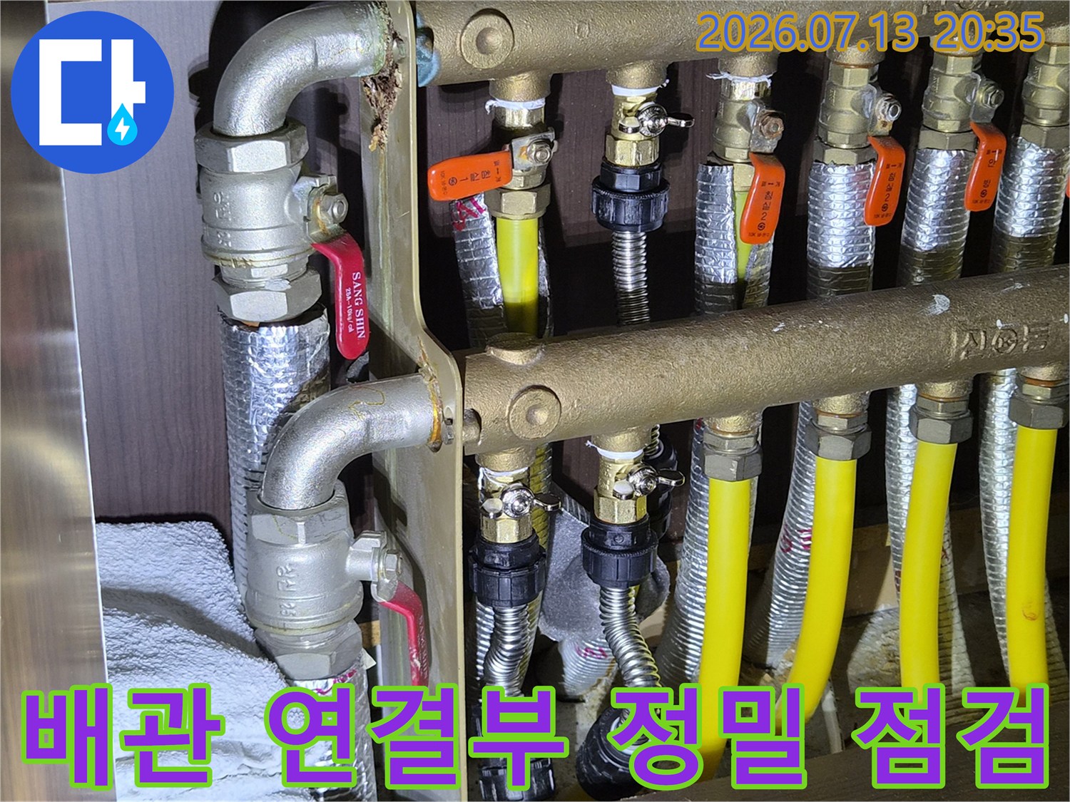 다채로운 배관이 얽힌 보일러실 내 분배기 및 노란색 호스 상세사진