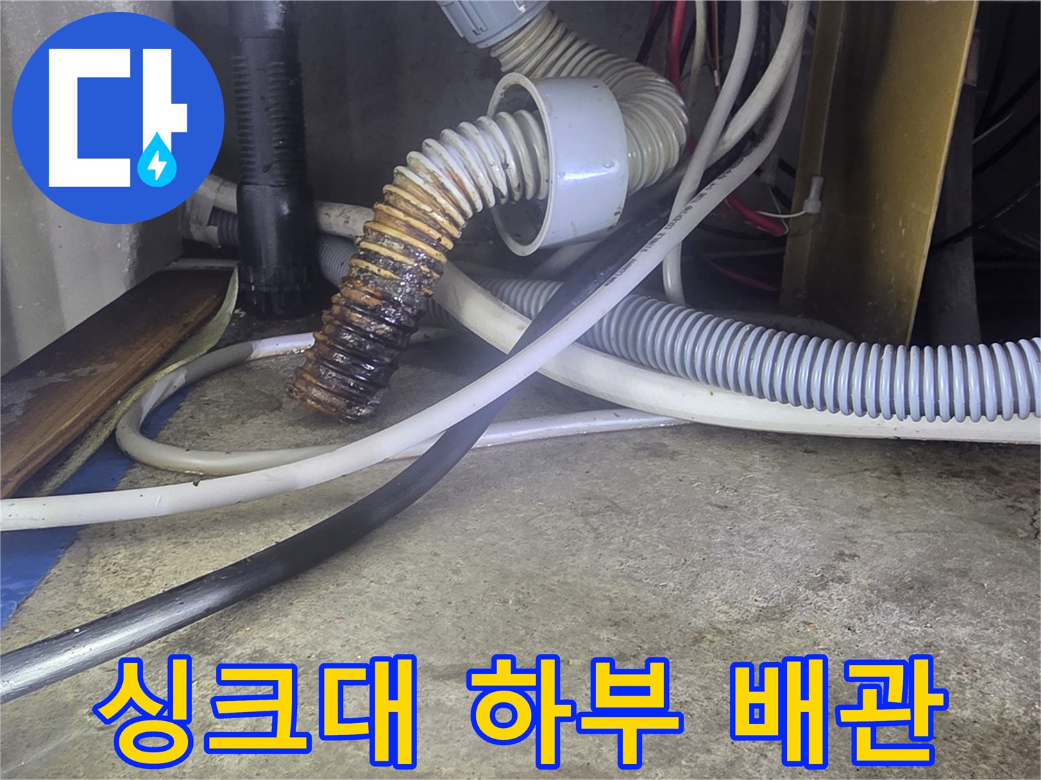 바닥에 놓인-주름진 호스와 굵은 배수관의 배치 상태