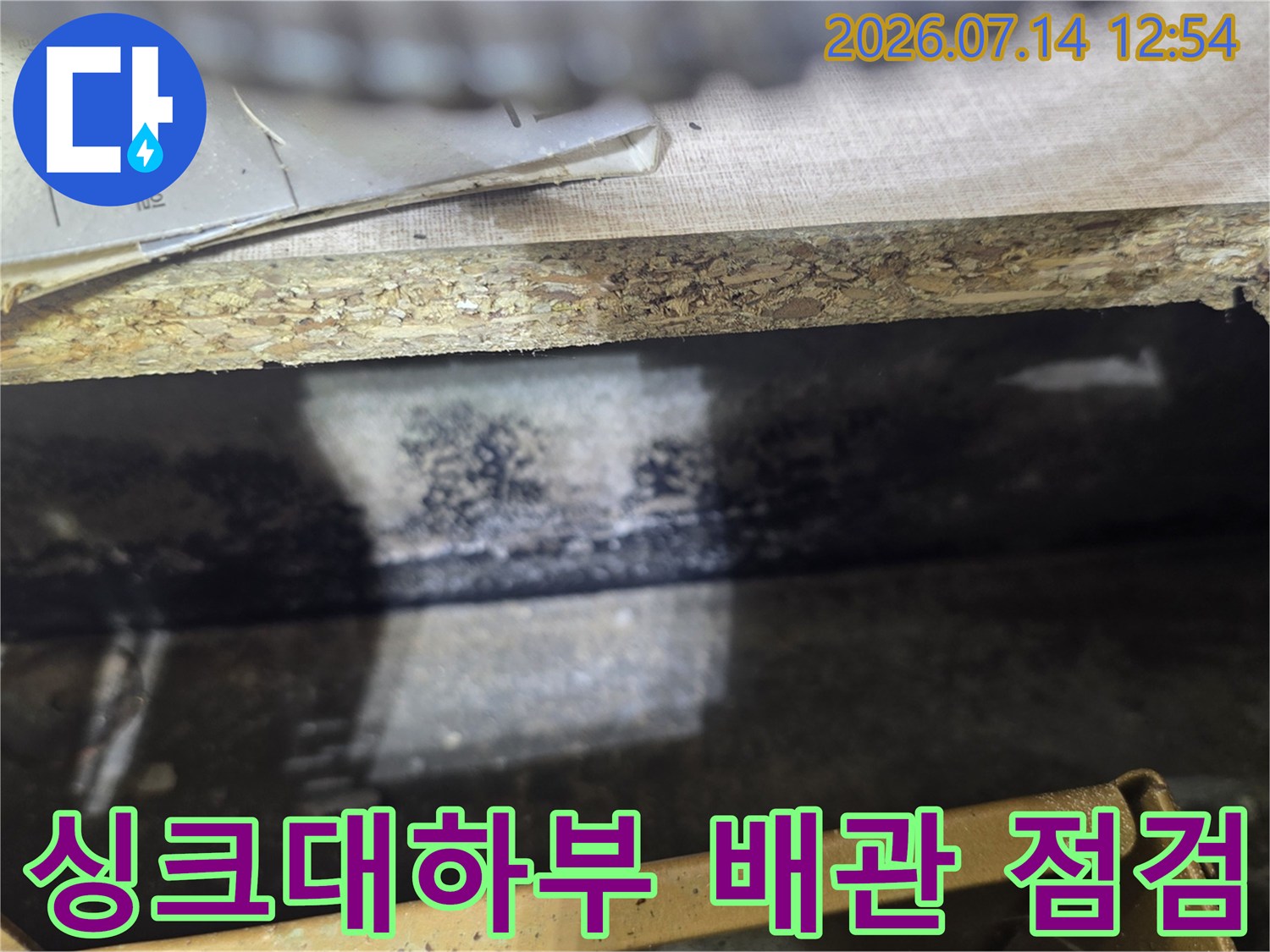 싱크대 하부 공간에서 확인한 누수 지점의 노출된 배관과 주변 환경