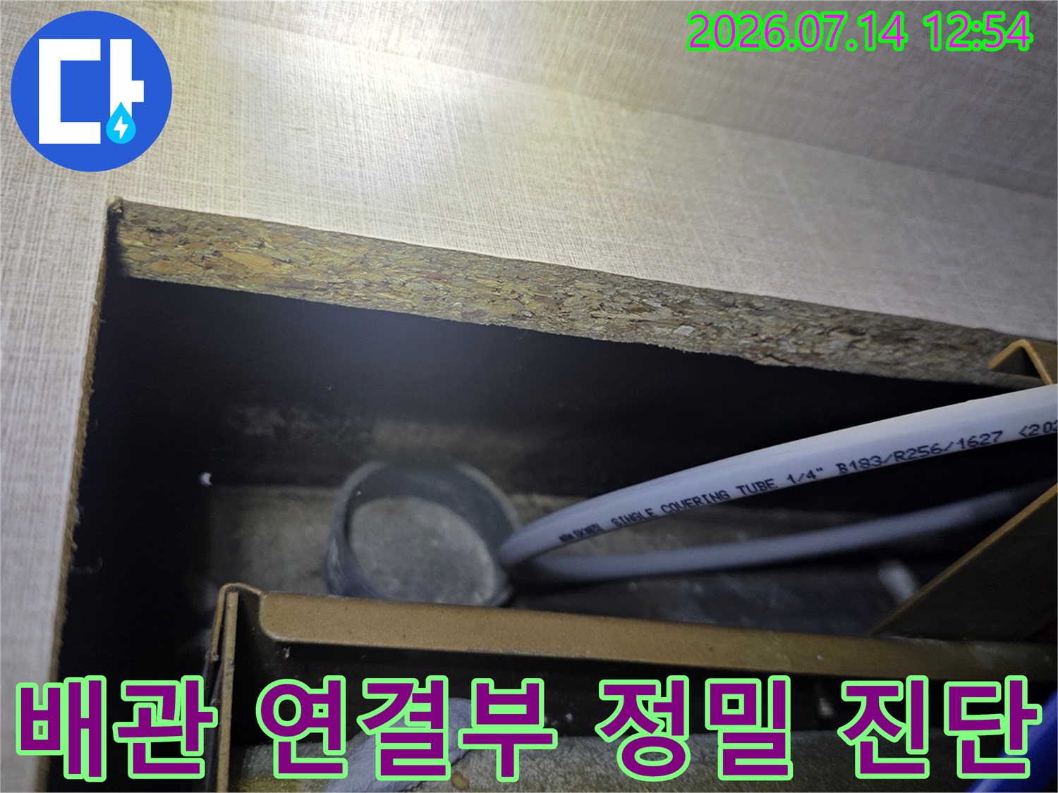 싱크대 하부에 위치한 배관의 마감 상태와 체결 부위를 정밀하게 점검하는 모습