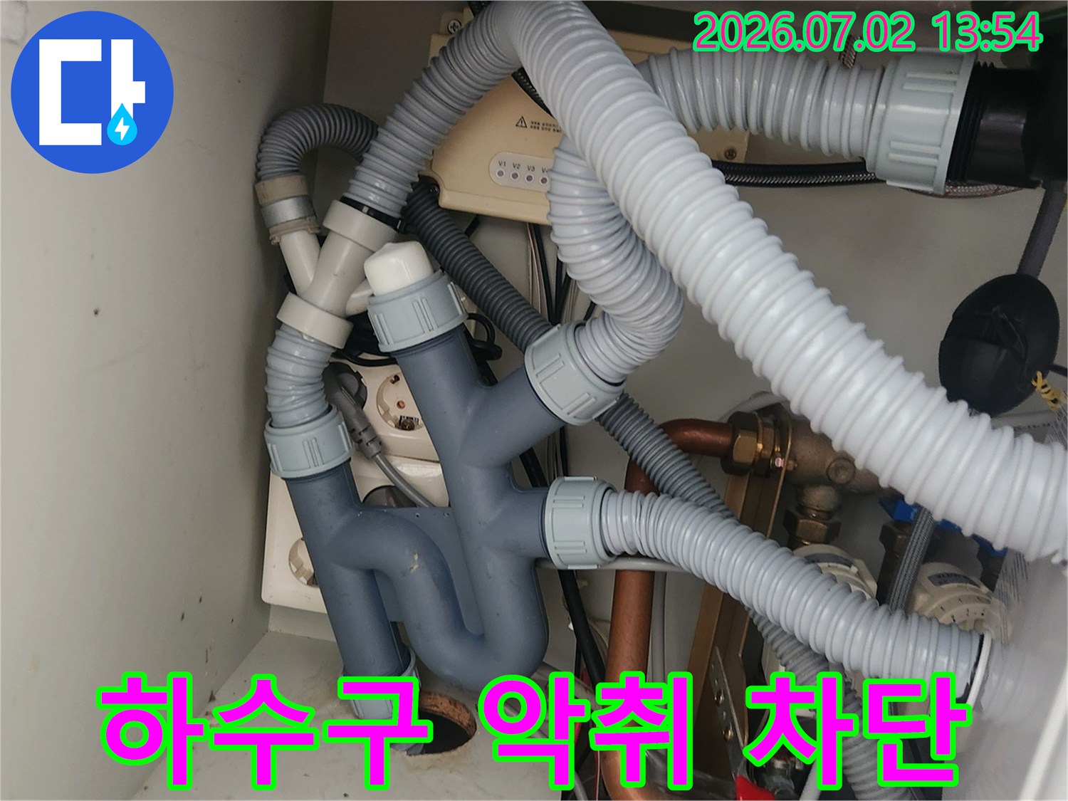 이 사진은-싱크대 하부의-배수관과 트랩을-세밀하게 보여주며-하수구 악취 역류를-방지하기 위한-정확한 시공의-중요성을 강조합니다.