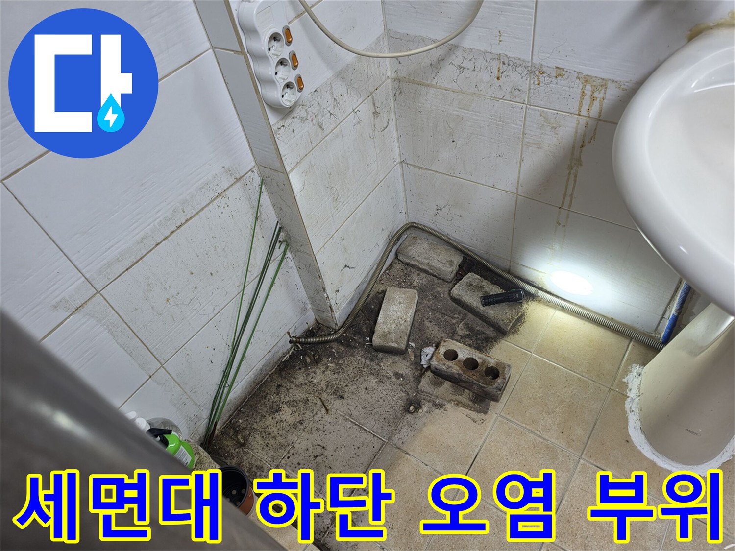 세면대 아래 벽면 타일에 나타난 물샘 자국과 곰<0xAE>팡이
