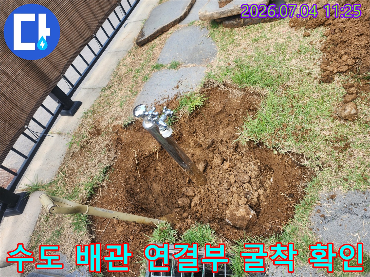 흙을 파내고 노출된 수도 배관과 작업용 도구들