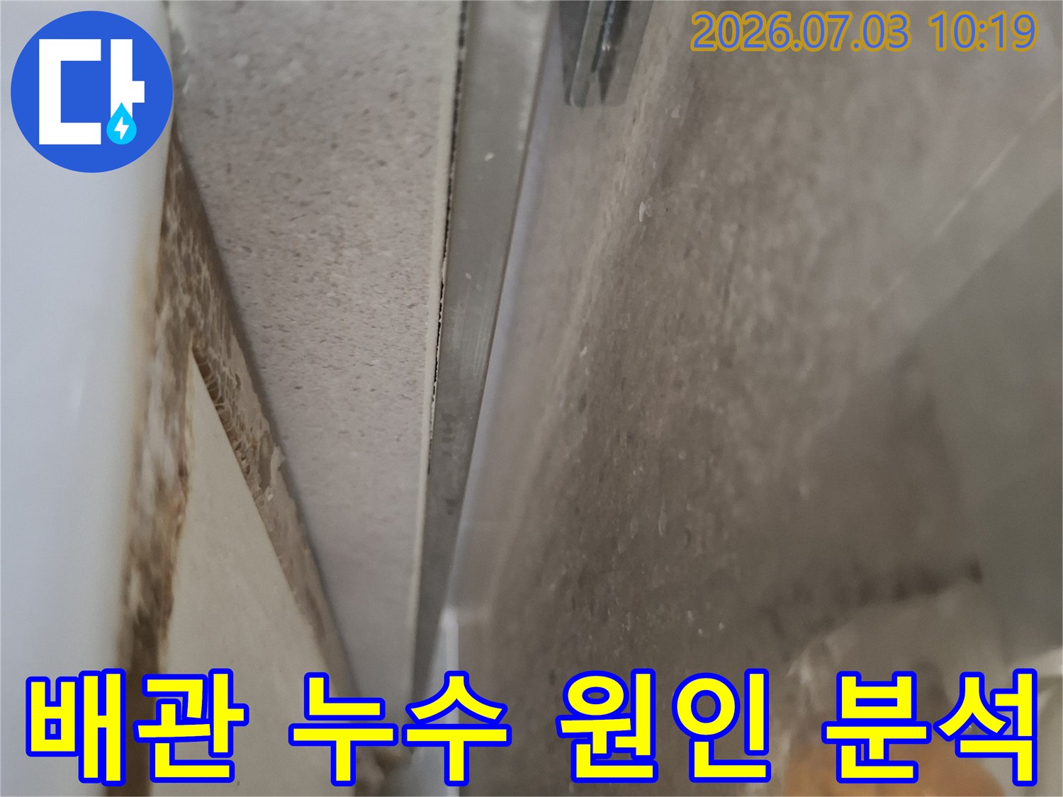 천장 내부 공간에서 배수 관련 부품과 연결부의 상태를 꼼꼼하게 점검하는 모습입니다.