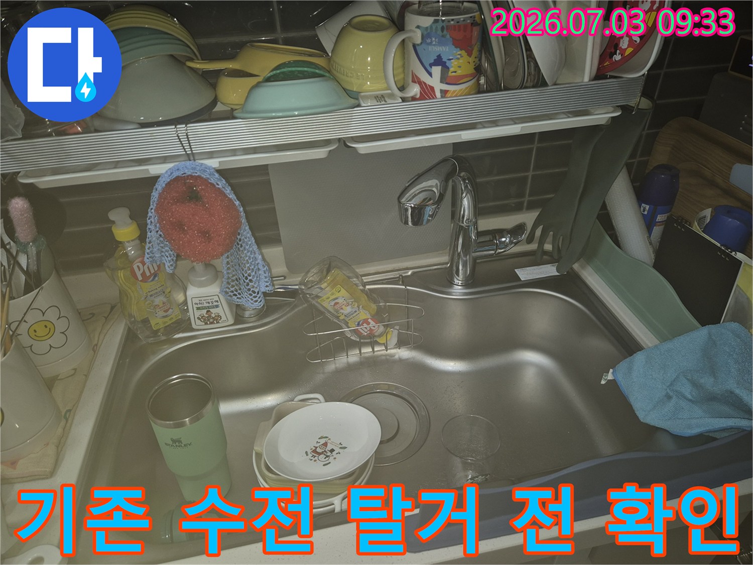 싱크대에 설치된 노후 수전과 주변 세정제들이 배치된 모습