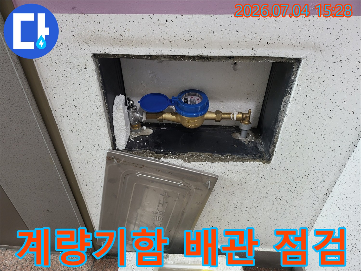 계량기함 내부의 노출된 수도 배관과 계량기 부속품 점검 모습