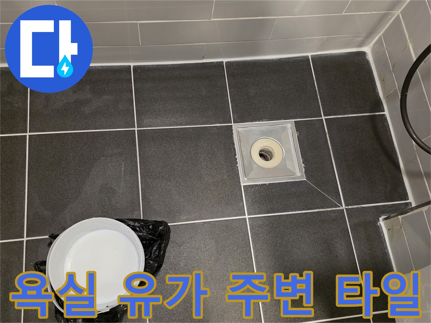 회색 타일과 배수구 트랩의 연결 부위 모습
