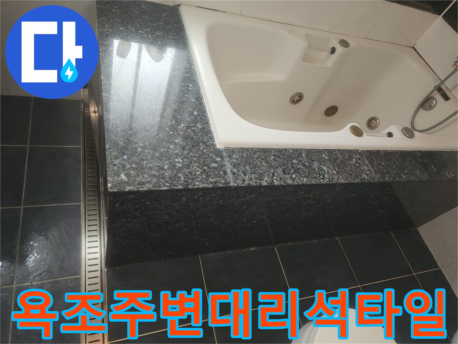 어두운색 대리석과 타일로 마감된 욕조 주변 상세 사진