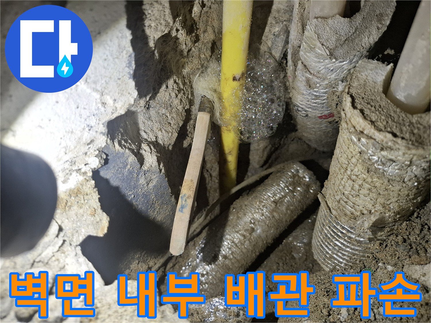 콘크리트 굴착 부위 내부에 노출된 손상된 온수 배관의 모습