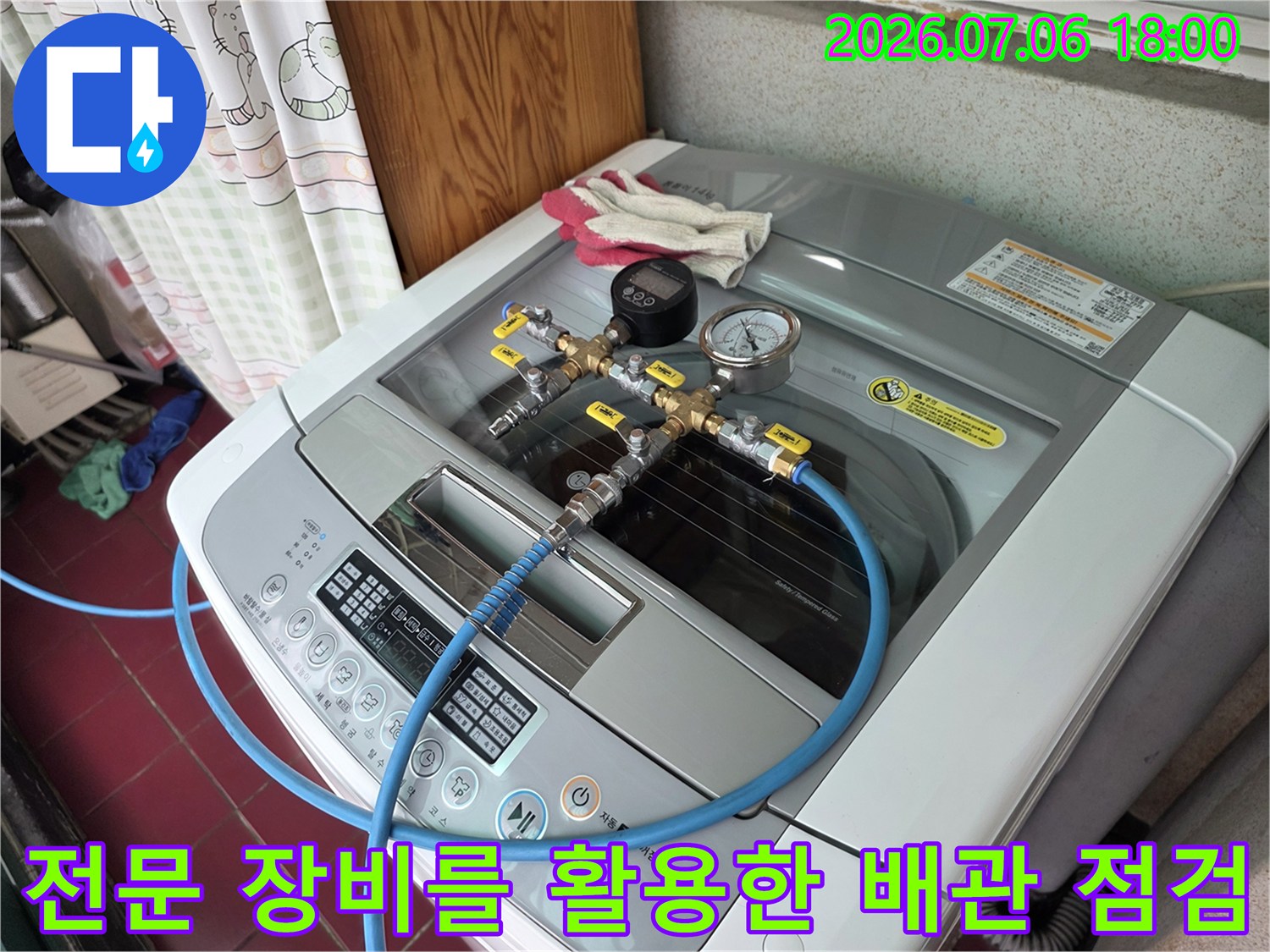 세탁기 위 노출된 배관에 연결되어 압력을 측정하는 누수 탐지 장비 구성