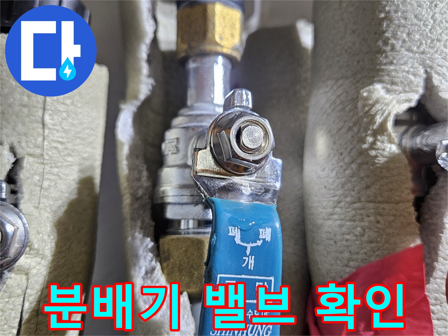 금속 밸브와 파란색 손잡이-보온재로 감싸진 분배기 부위