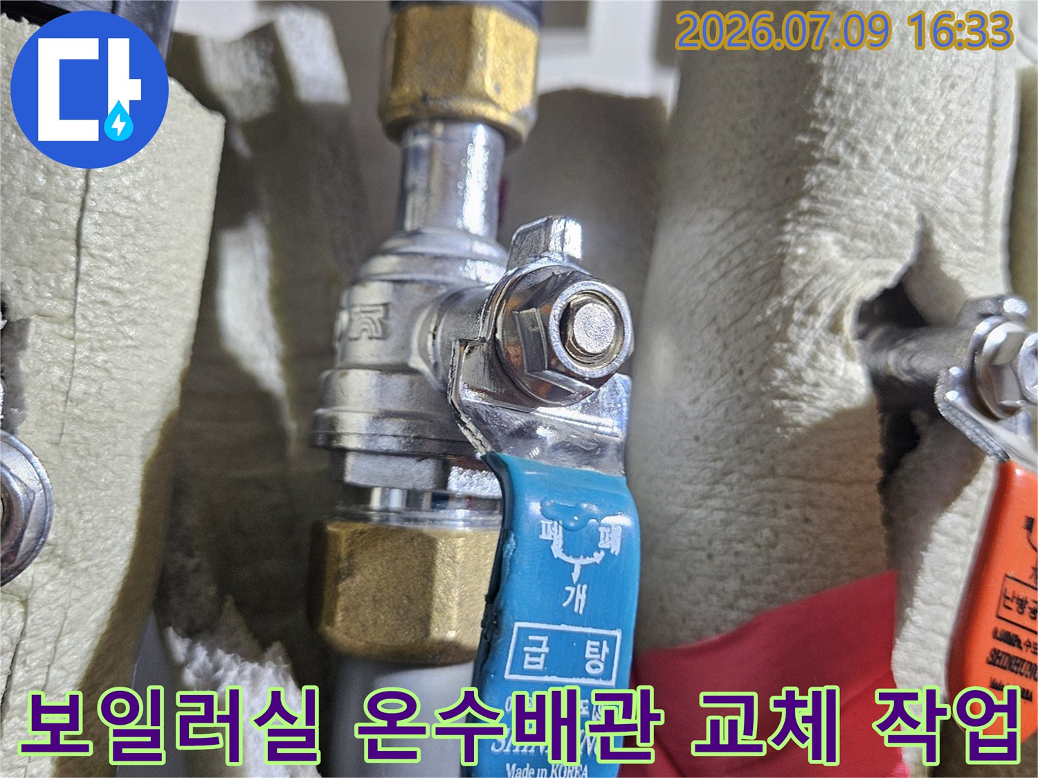 보일러실 내 노출된 온수배관에 연결된 밸브와 배관 자재를 확인하는 모습
