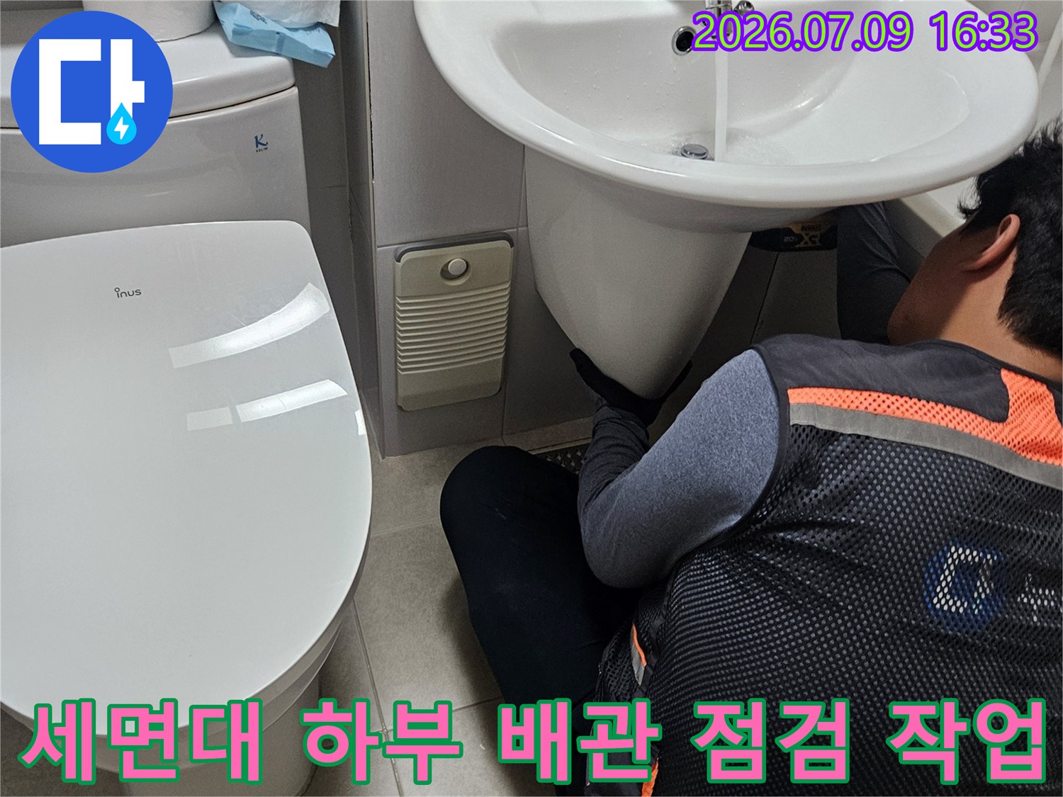 세면대 밑의 복잡하게 연결된 배관 시스템을 전문가가 직접 정밀 진단함
