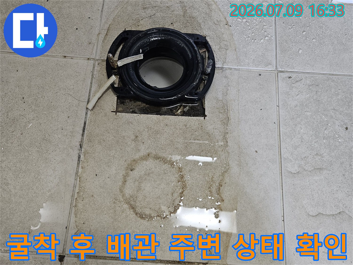 타일을 제거하고 노출된 회색 배관과 습기에 의한 변형 부위
