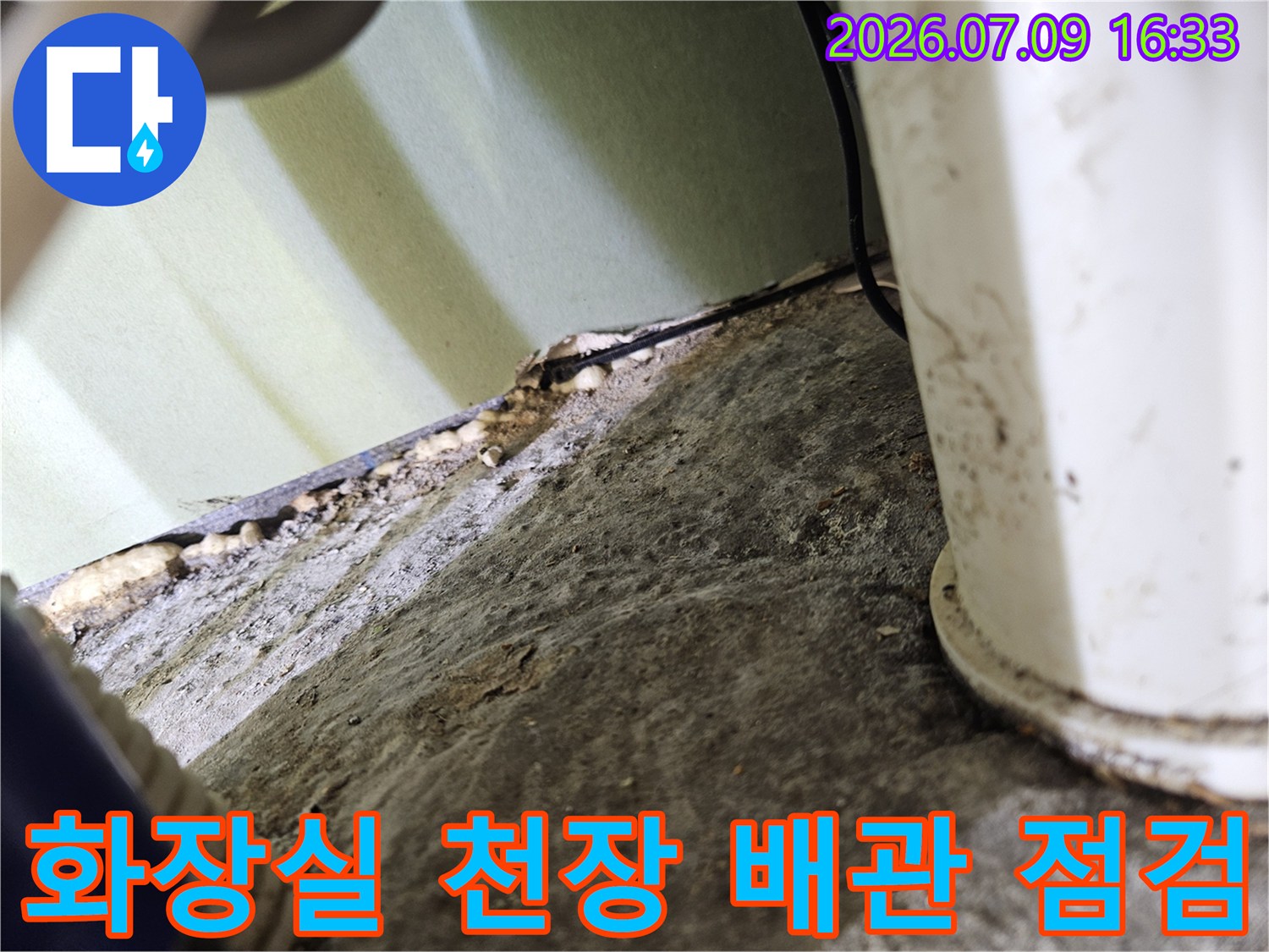 화장실 천장 내부의 노출된 배관과 주변면 상태를 정밀하게 점검하는 모습