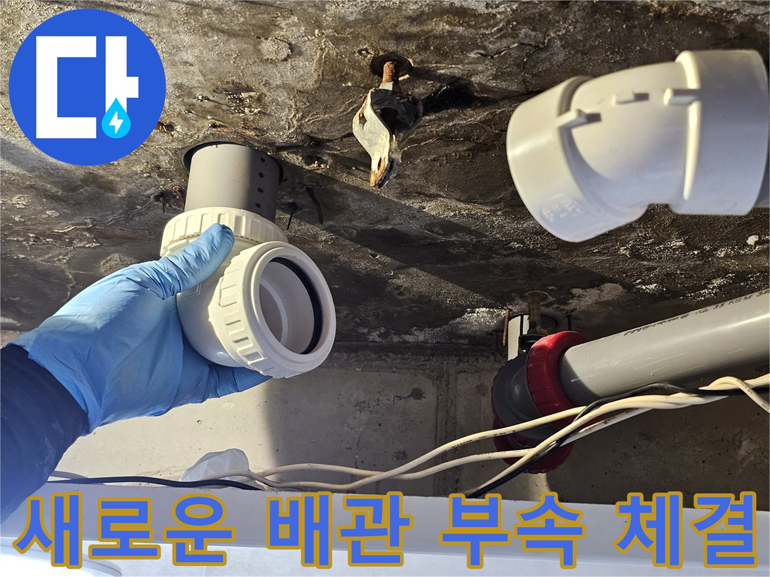 기존의 낡은 연결부를 제거하고 깨끗한 새 배관 부속을 준비하는 장면입니다.