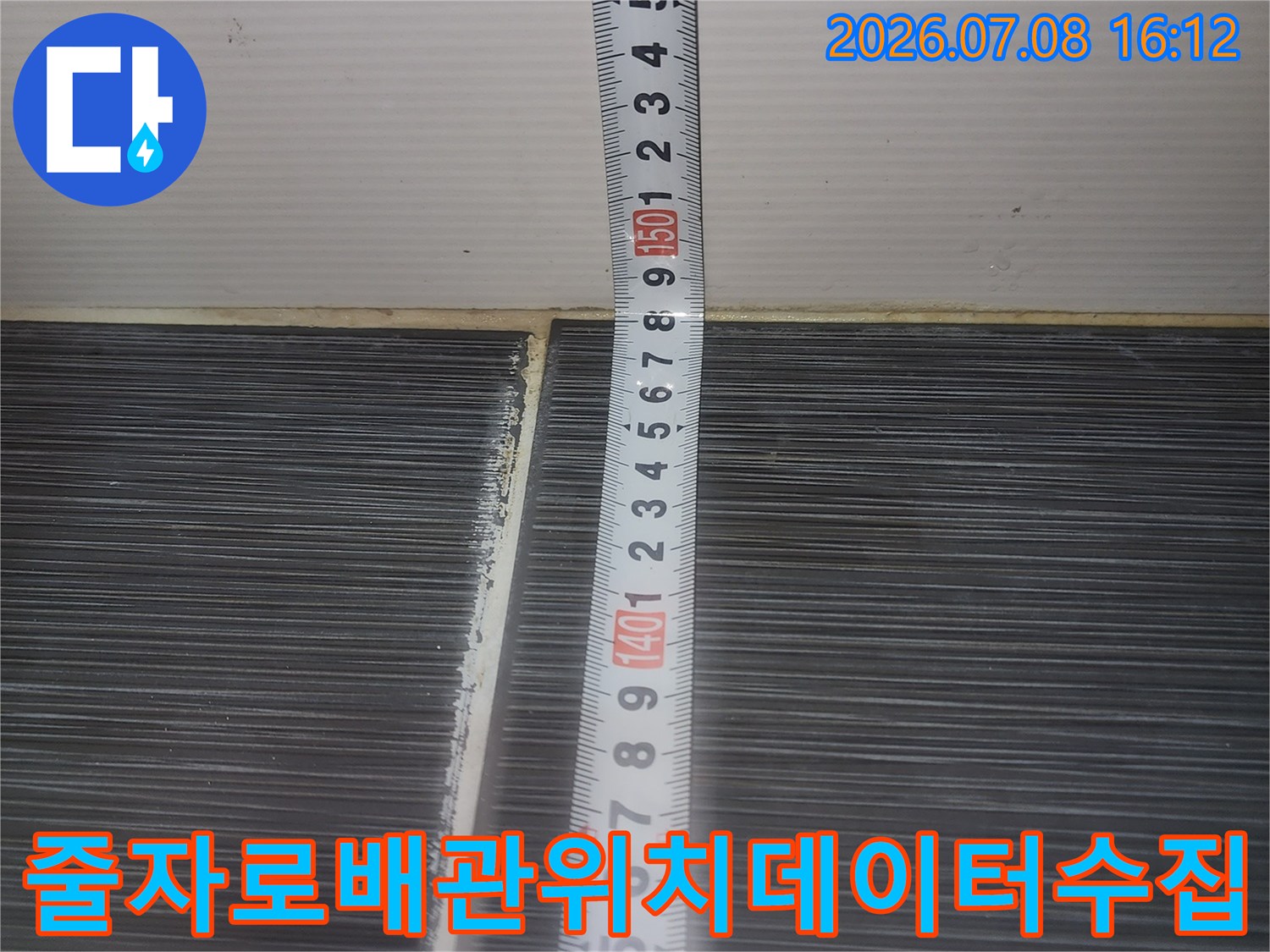 줄자를 사용하여 배관의 정확한 위치와 수치를 측정하며 기록하는 장면