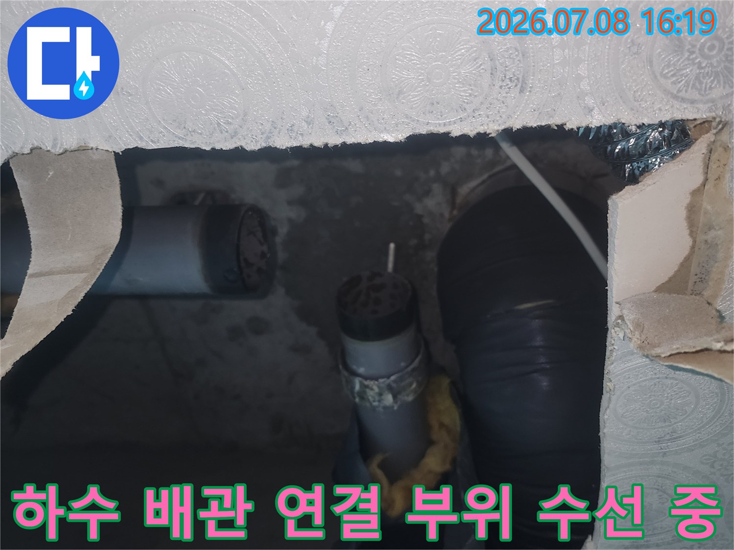 천장 내부에 위치한 파손된 하수 배관을 새 부속으로 교체하는 상세 장면