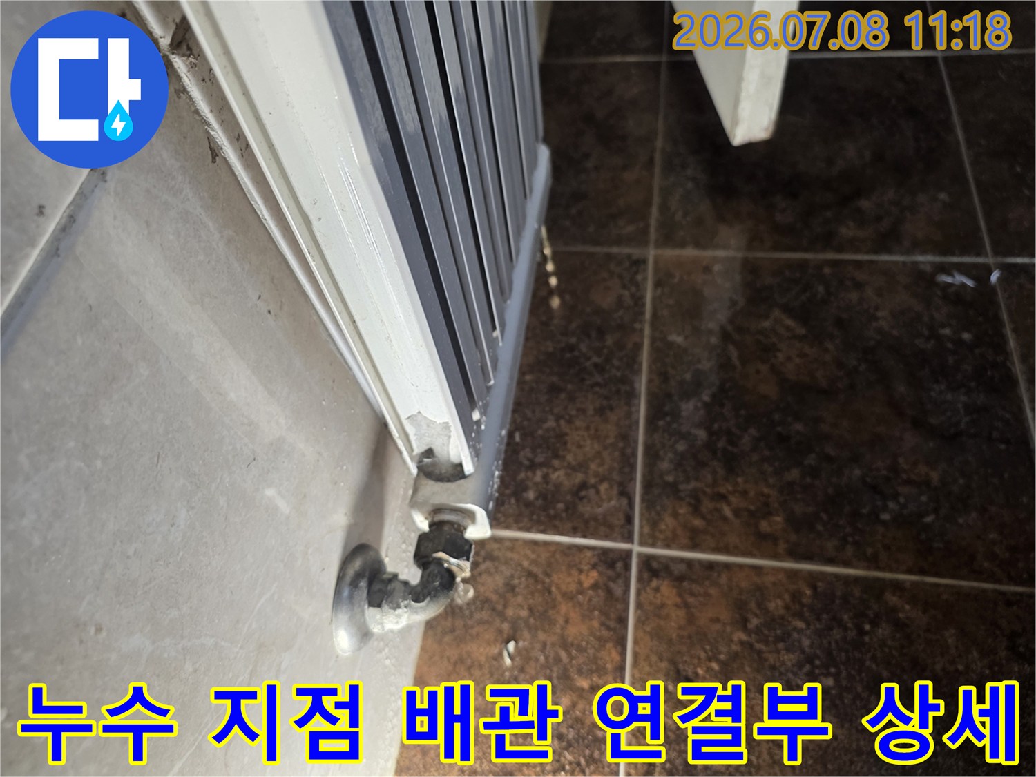 화장실 내 라지에터와 연결된 노출 배관 부위의 정밀 점검 장면