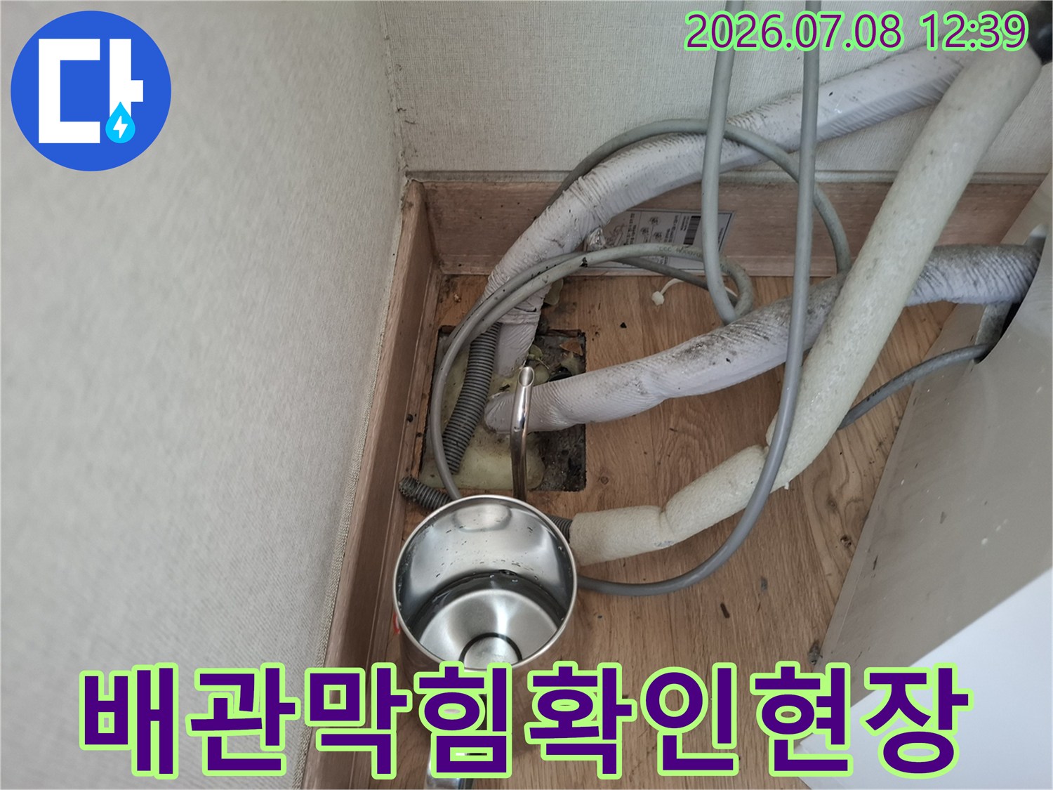 보온재로 감싼 배관과 연결부의 누수 여부를 확인하는 전문 장비와 작업 공간