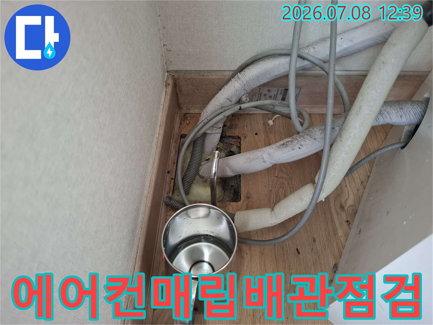 흰색 보온재로 감싸진 에어컨 매립 배관과 바닥면의 연결 부위 점검 모습