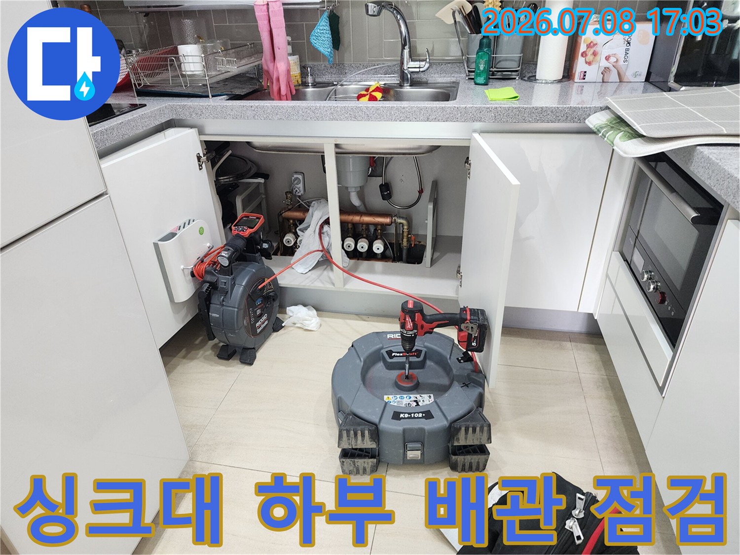 싱크대 아래 공간에서 내시경 카메라 장비를 활용해 배관 상태를 정밀 점검하는 모습