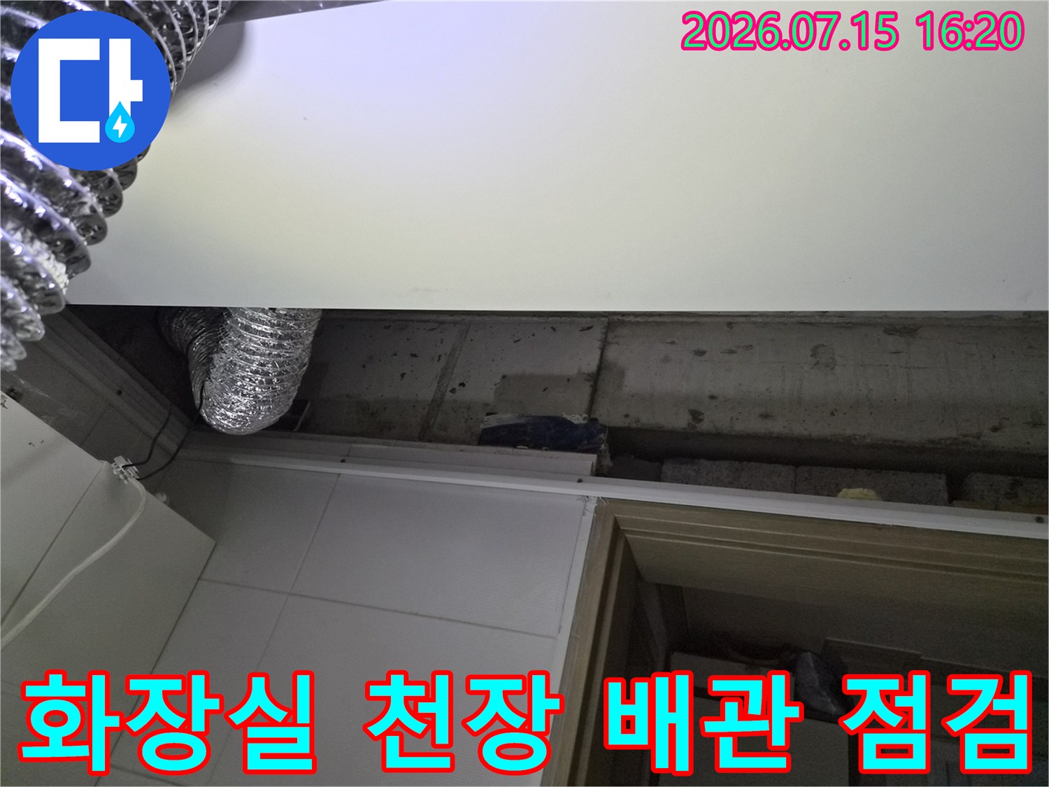 노출된 화장실 천장 내부의 은색 자재로 감싸진 배관과 환기 덕트 시설