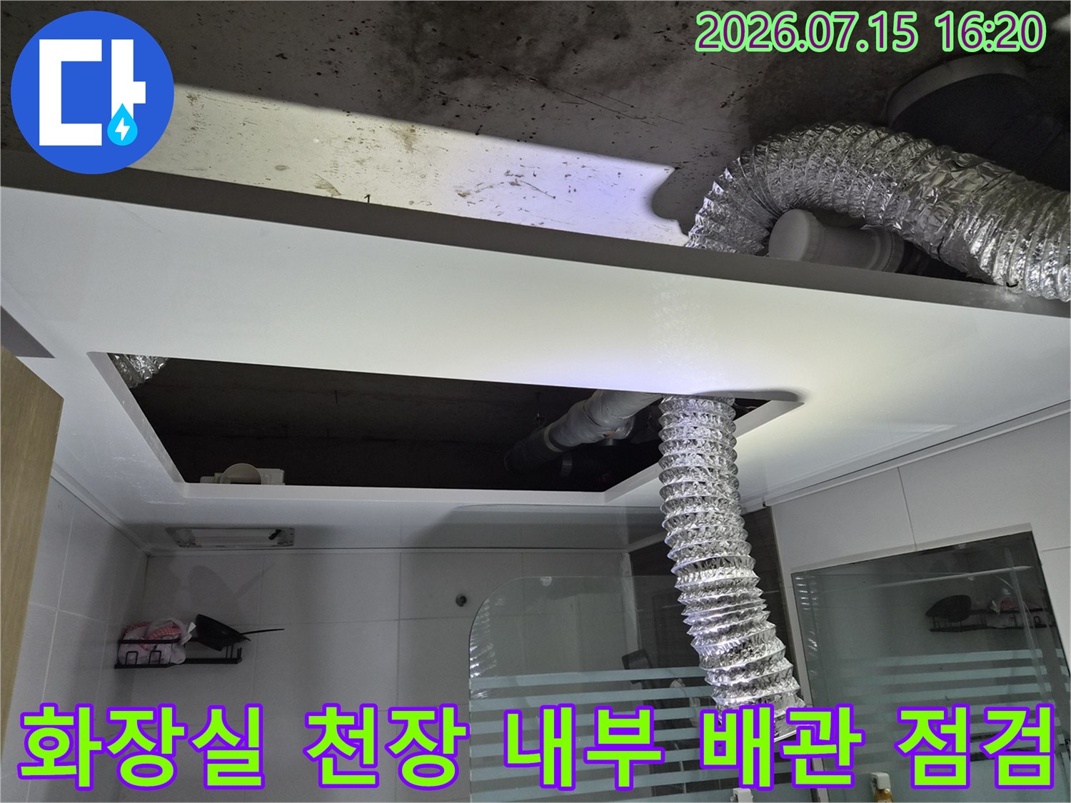 은색 단열재로 감싸진 배관과 화장실 천장 내부에 노출된 설비 시설